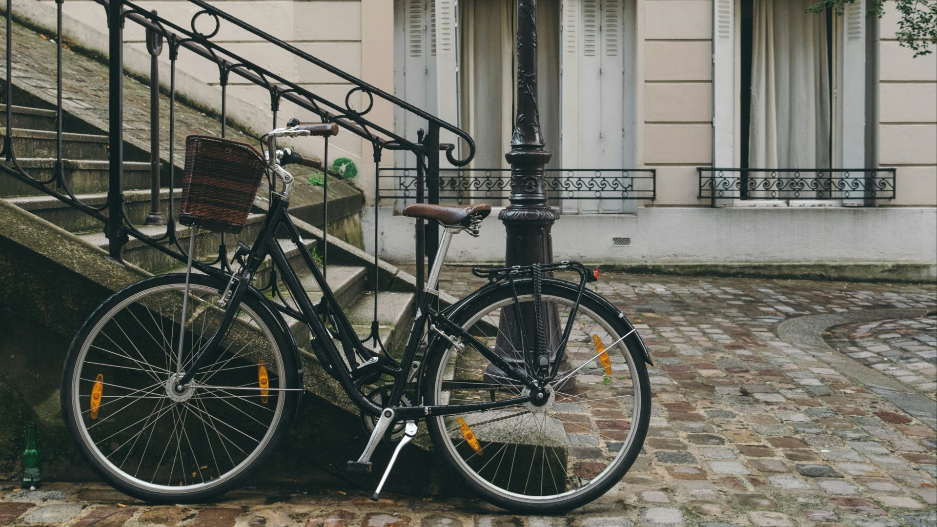bike leaning against handrail in front of concrete building at daytime