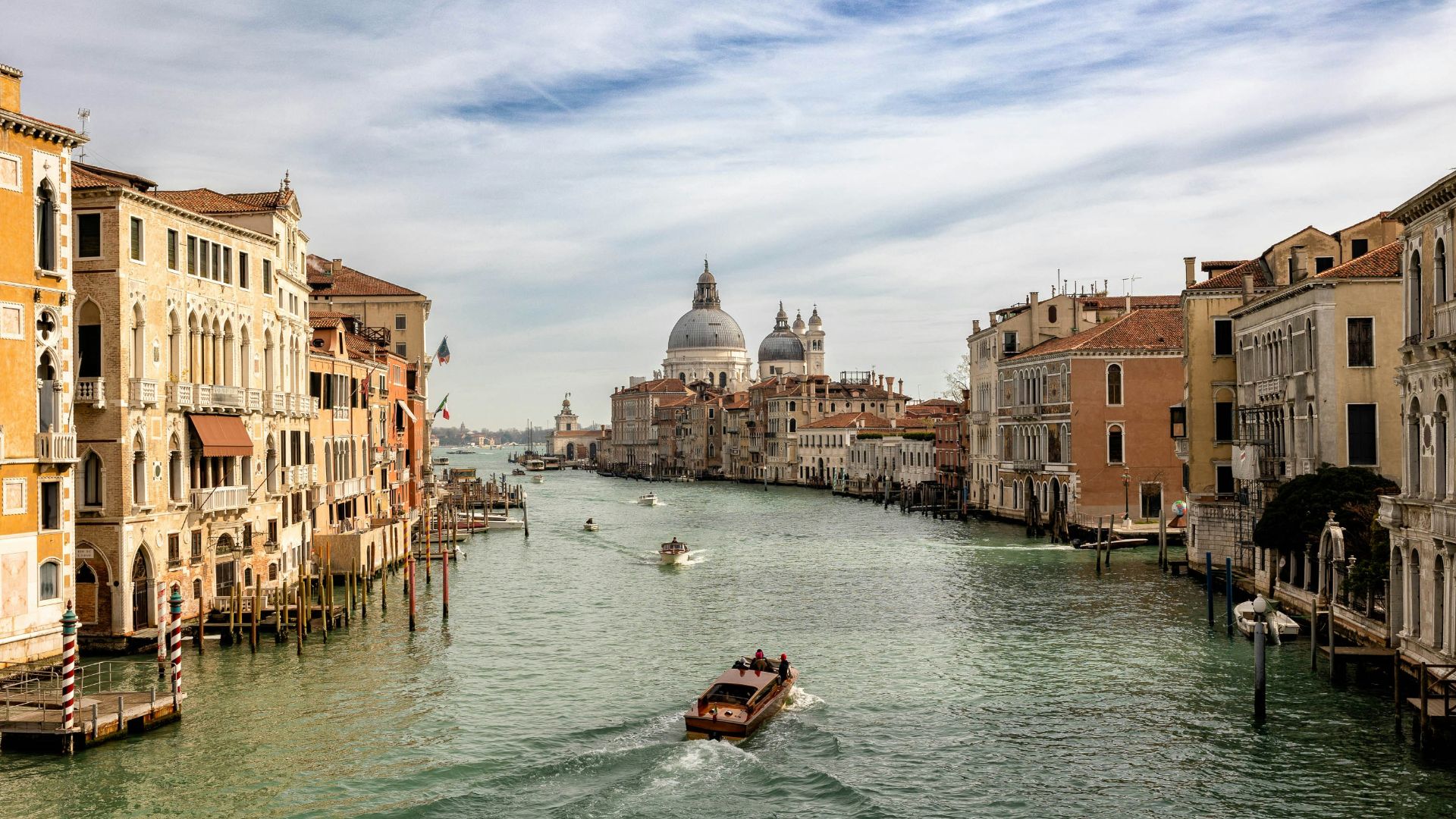 a boat traveling down a river next to tall buildings