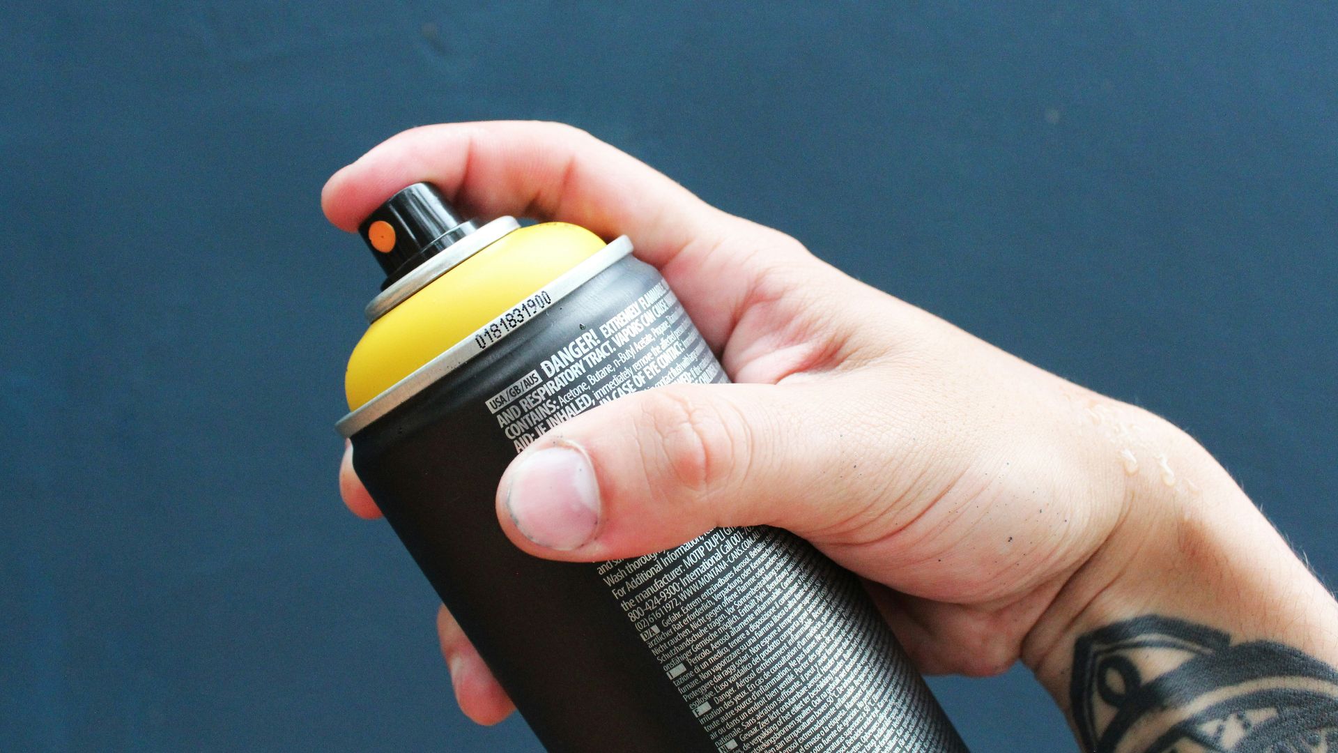 a person holding a black and yellow water bottle