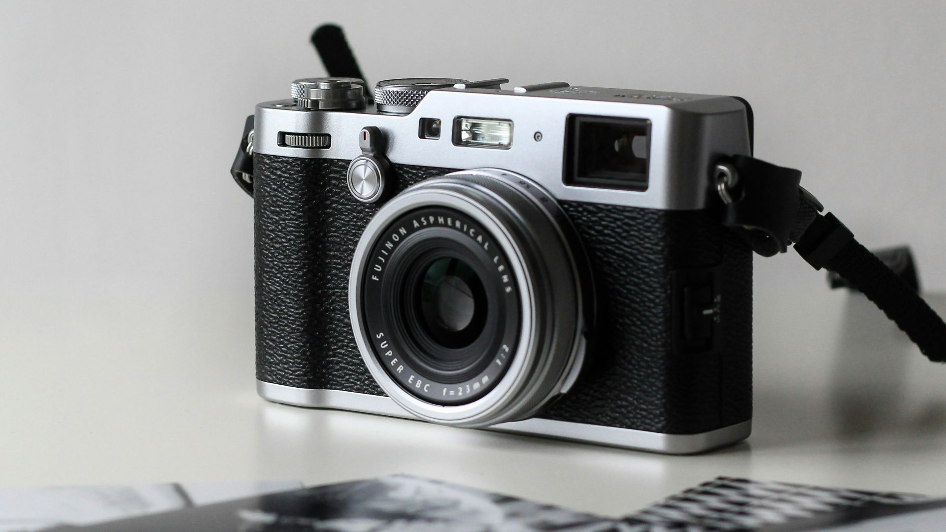 black and gray film camera near printed photos