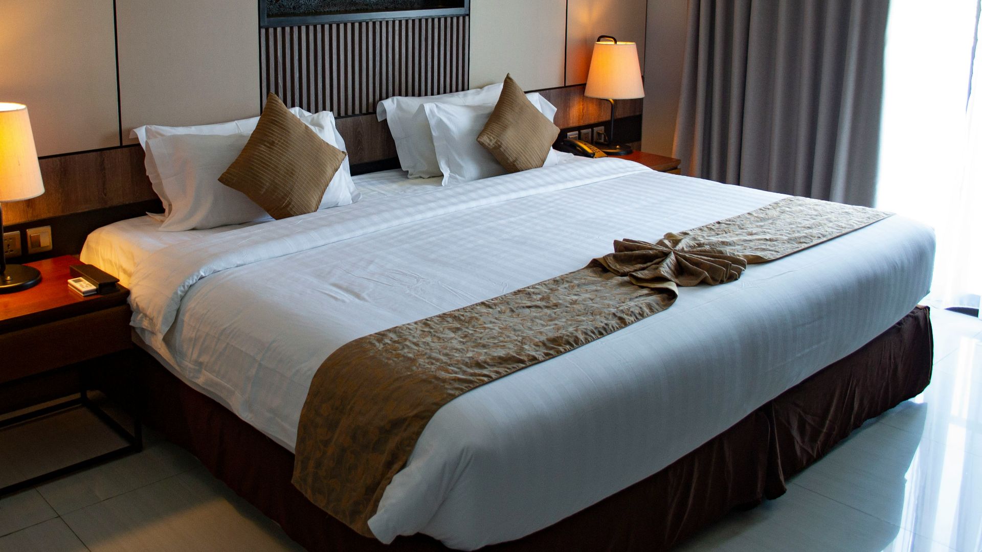 white bed linen with throw pillows