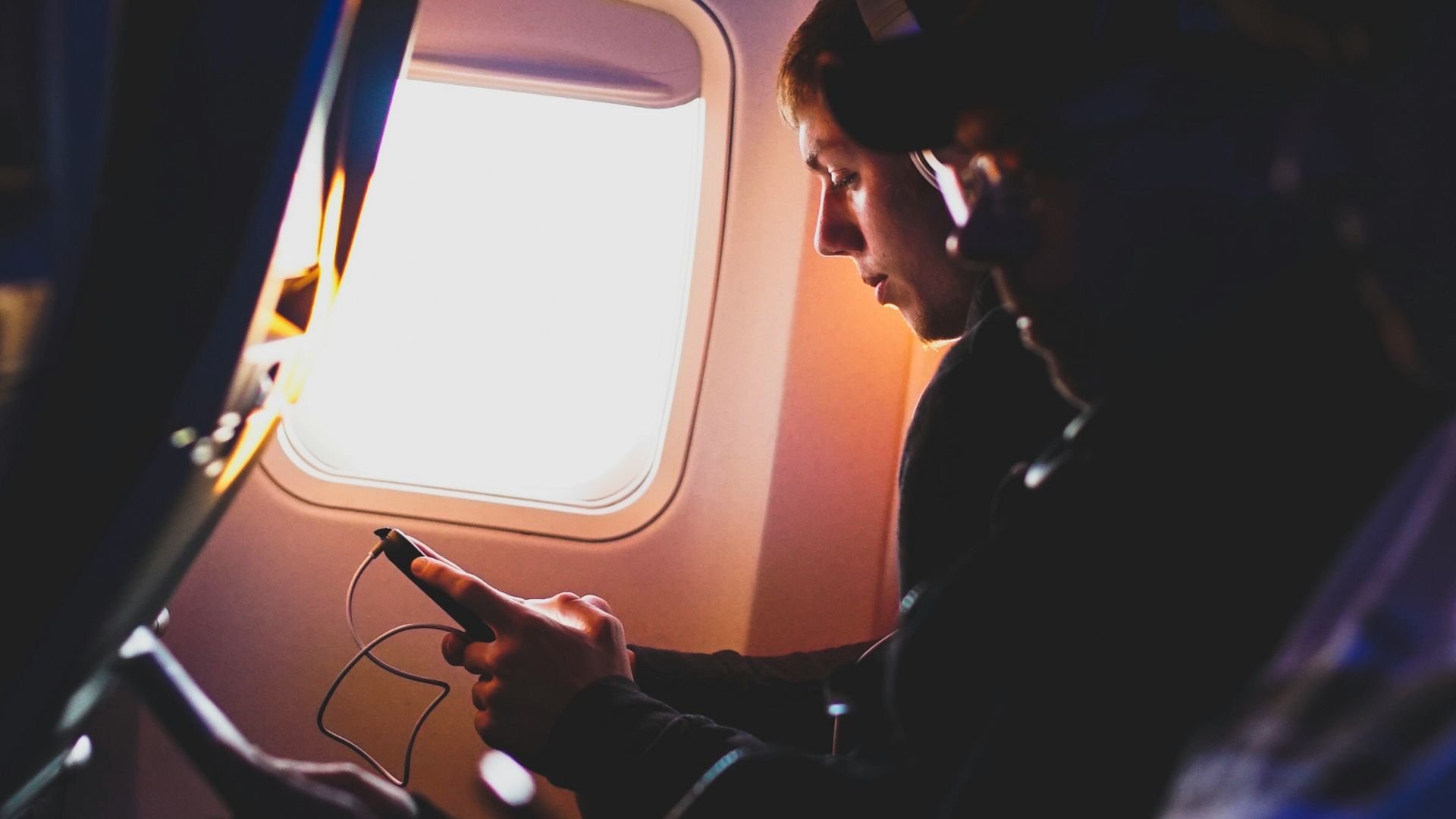 photo of three people listening to music inside airplane