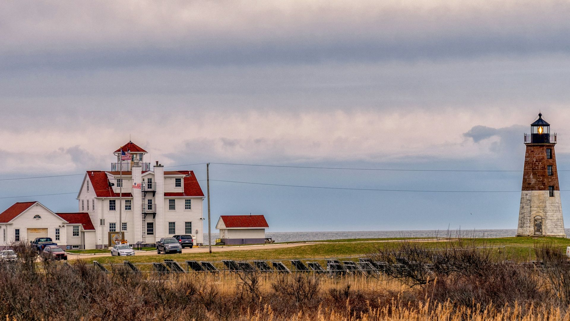 white and red house on green grass field under white clouds during daytime