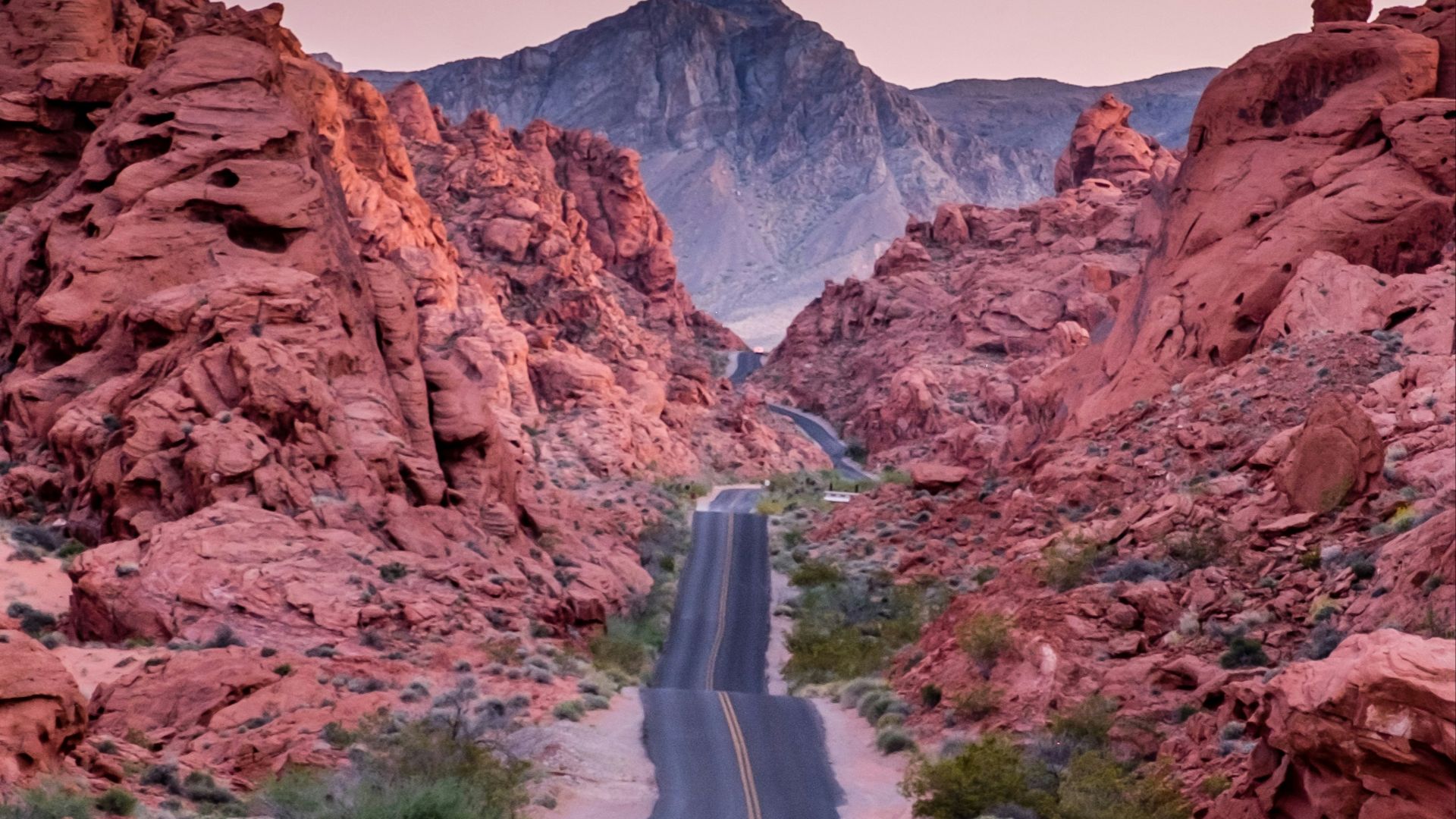 photo of empty road between rock formations