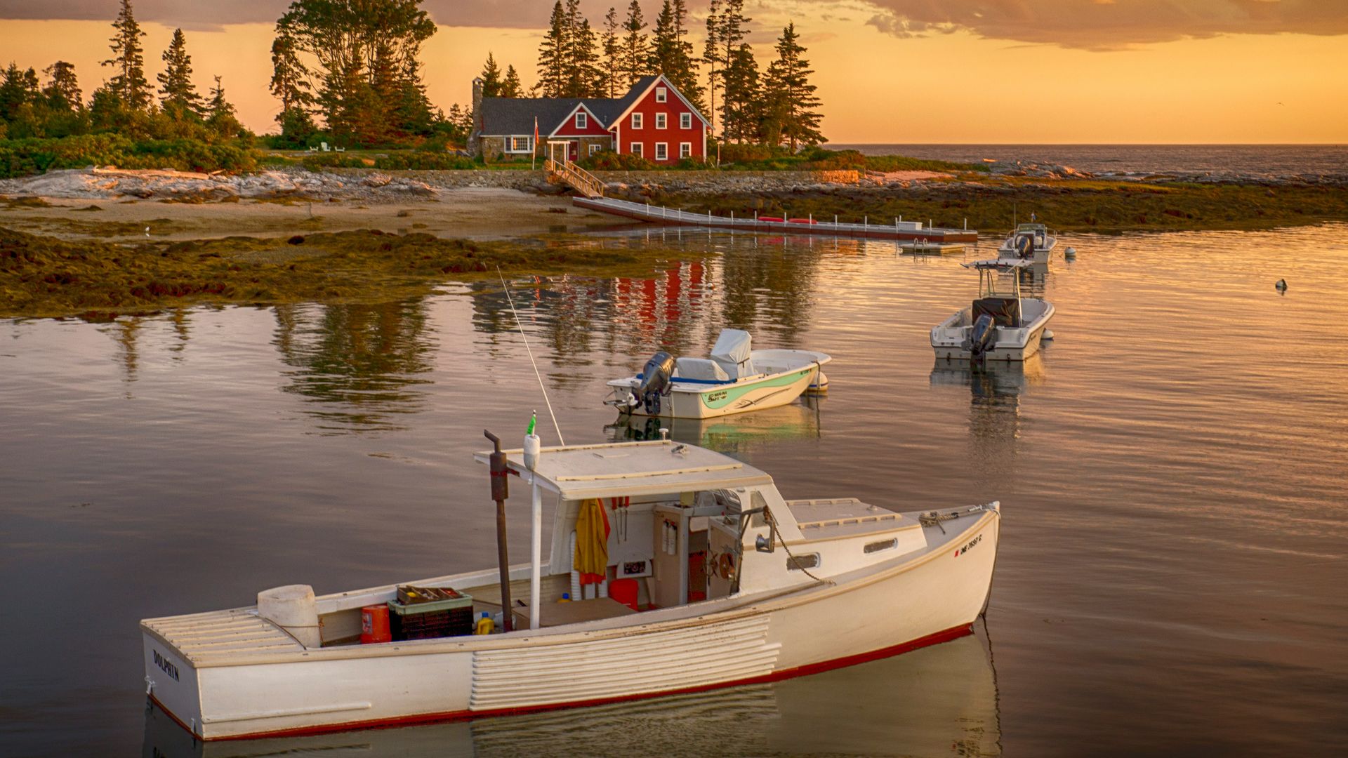 red house beside body of water with white motor boats during daytime
