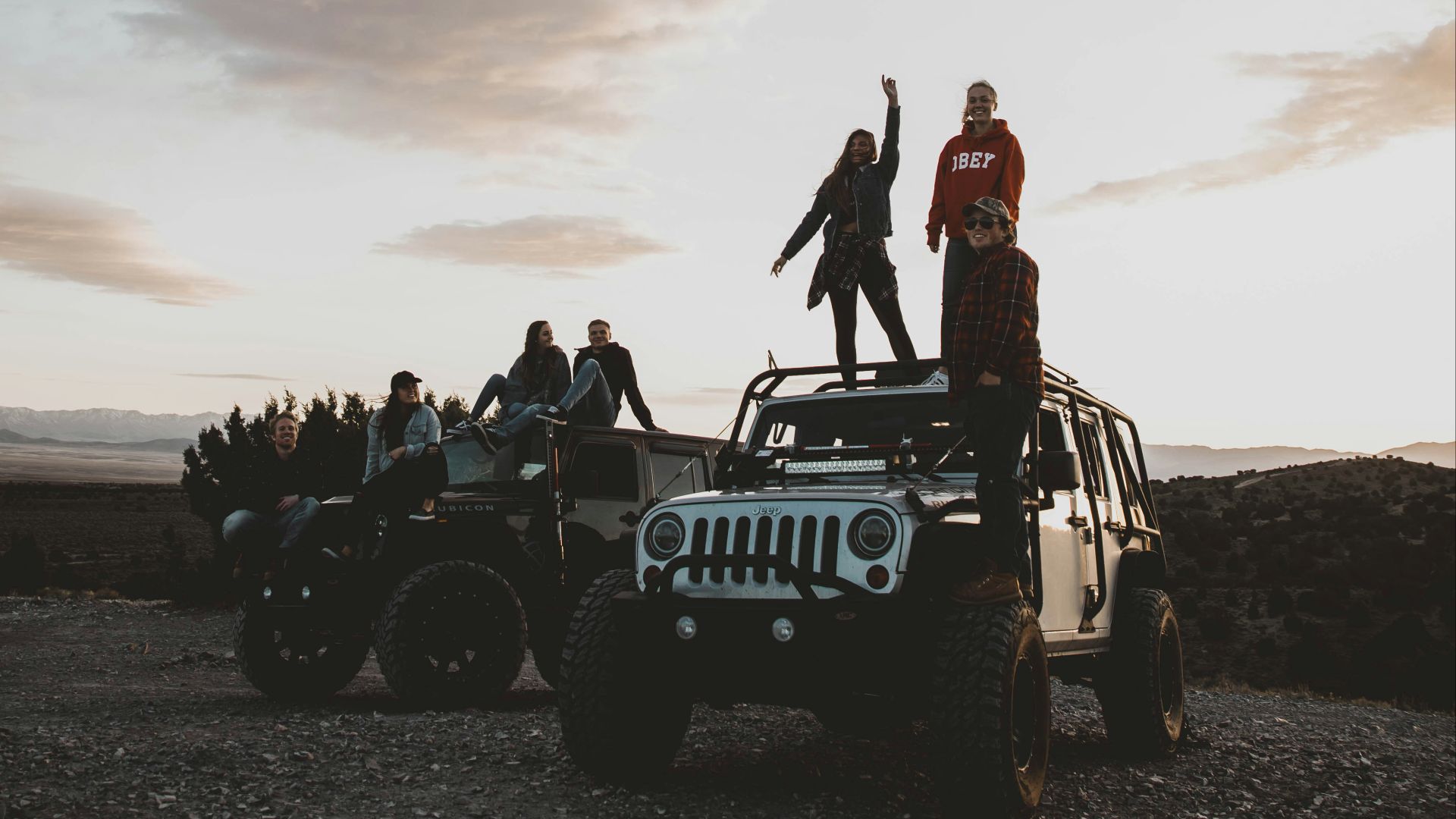 person standing on top of vehicle under white sky