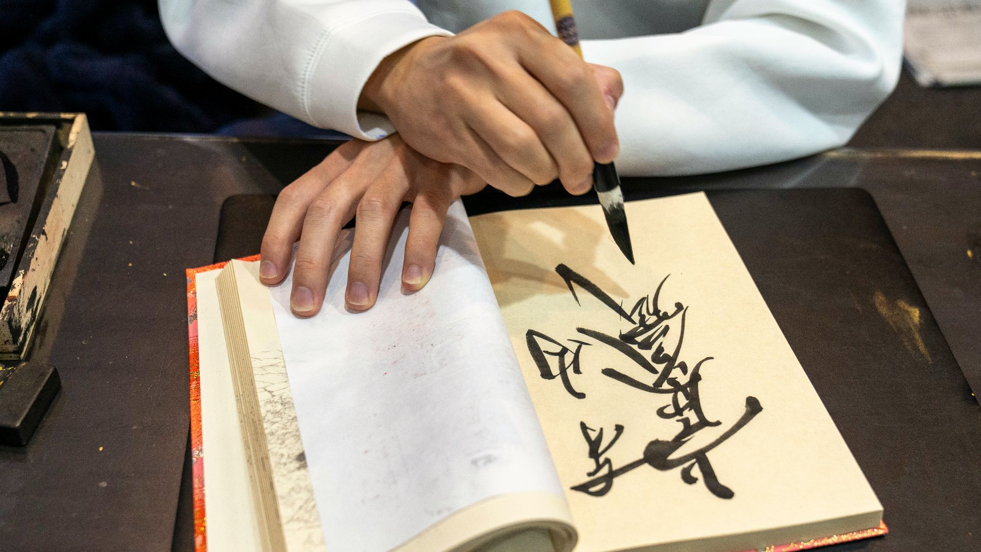 a person with a pen writing on a book