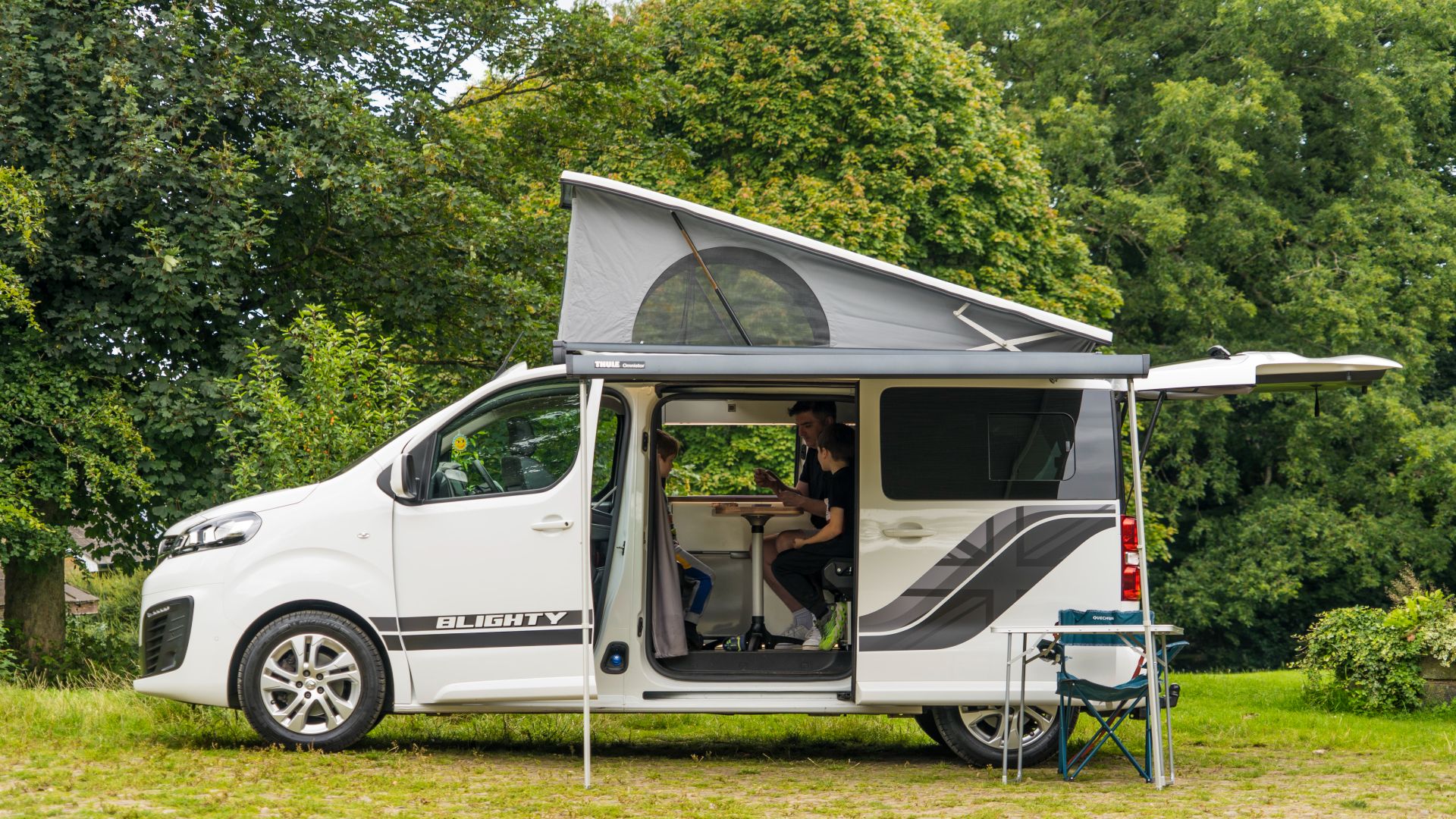 File:Camper van with family inside playing games.jpg