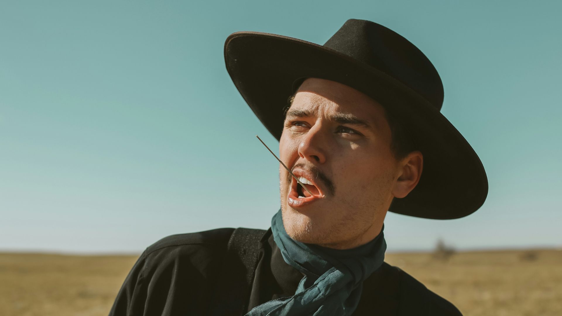 man in black jacket wearing blue and white scarf and black hat