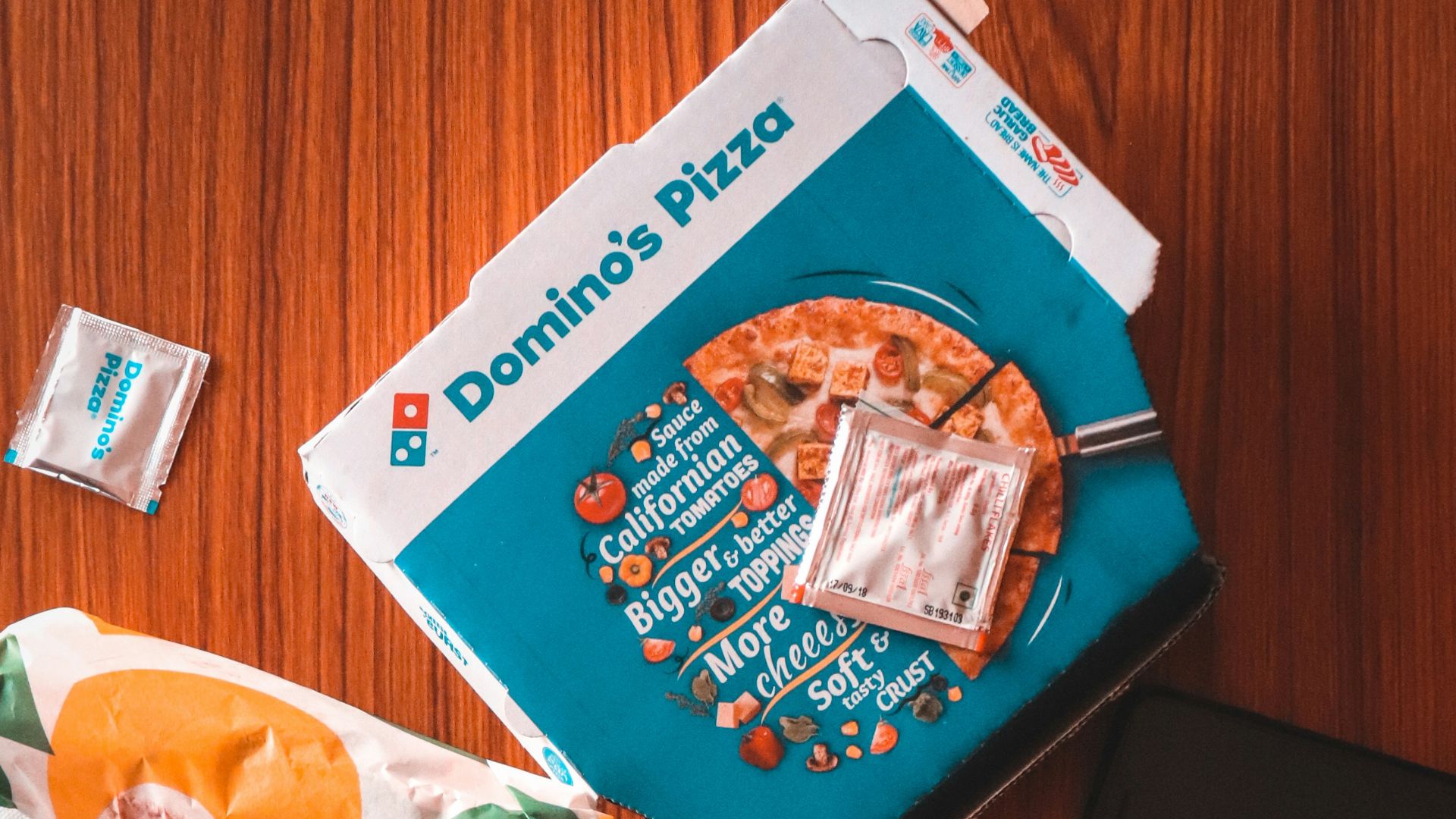 pizza and sauce packs beside iPhone on table