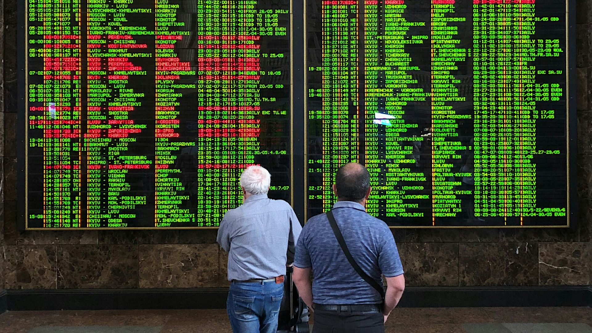 man in blue denim jacket standing beside man in gray jacket
