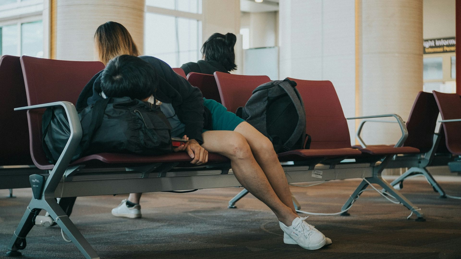 unknown person lying on brown bench indoors