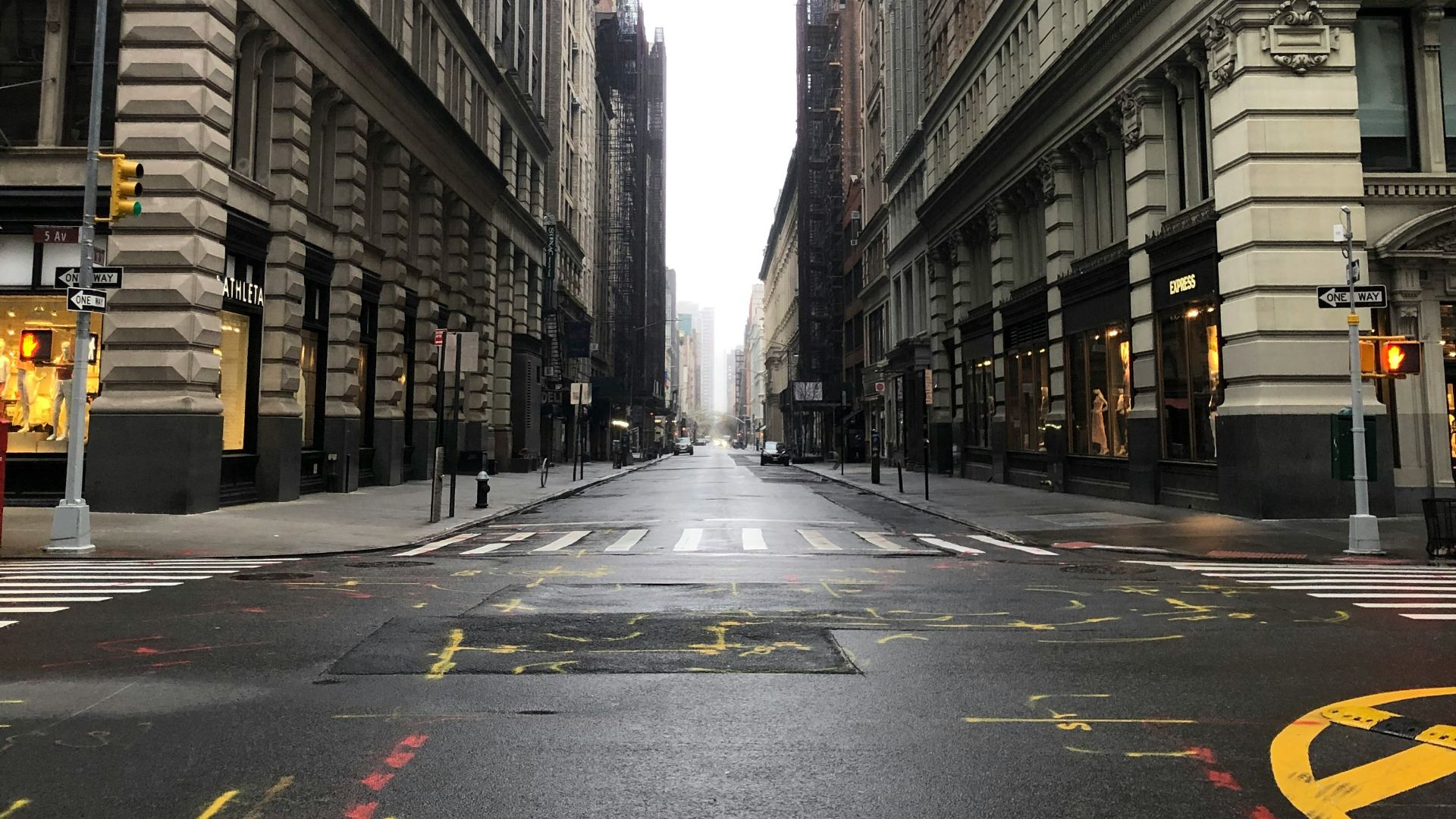 black and yellow pedestrian lane in between of high rise buildings during daytime