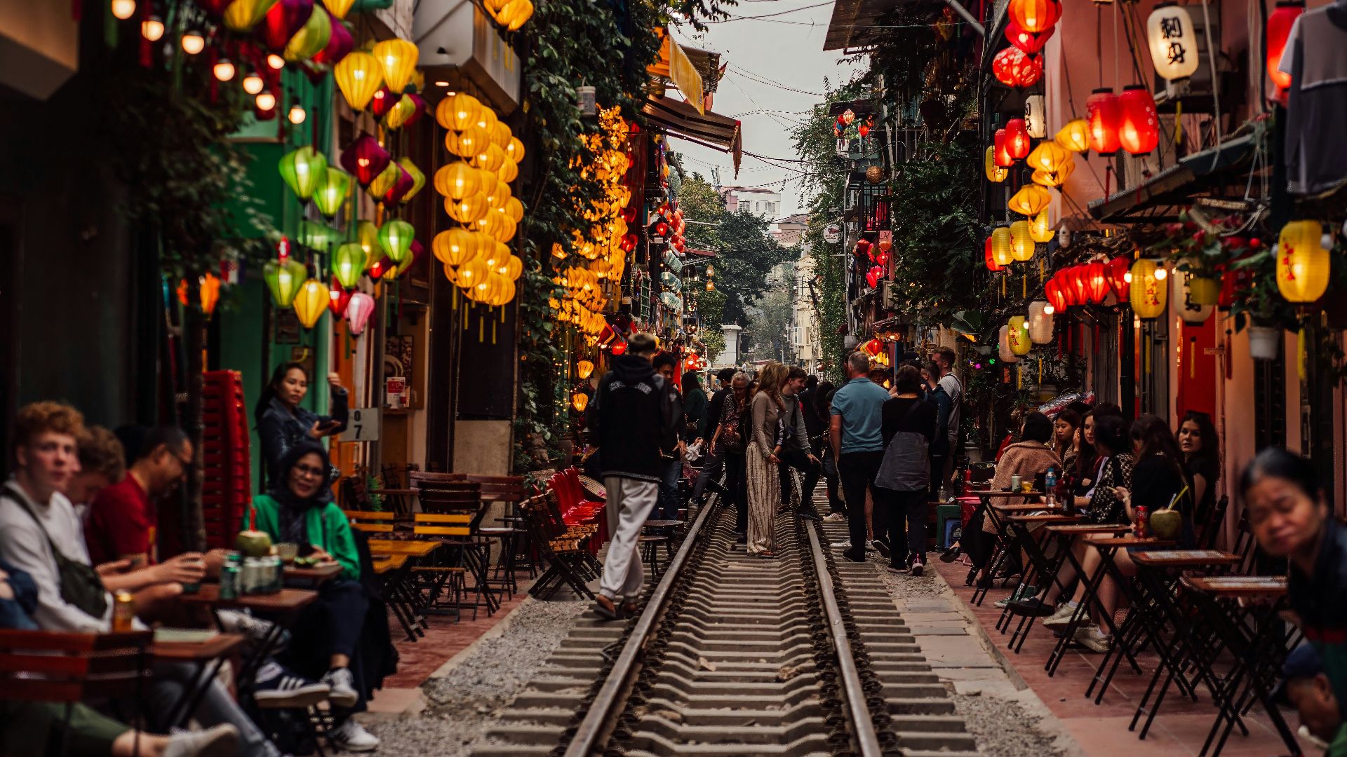 a group of people walking down a train track