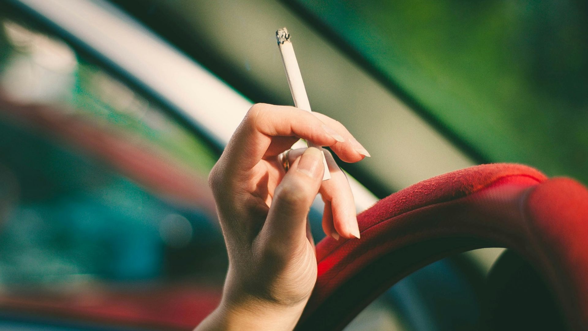 selective focus photography of single cigarette stick on person's hand