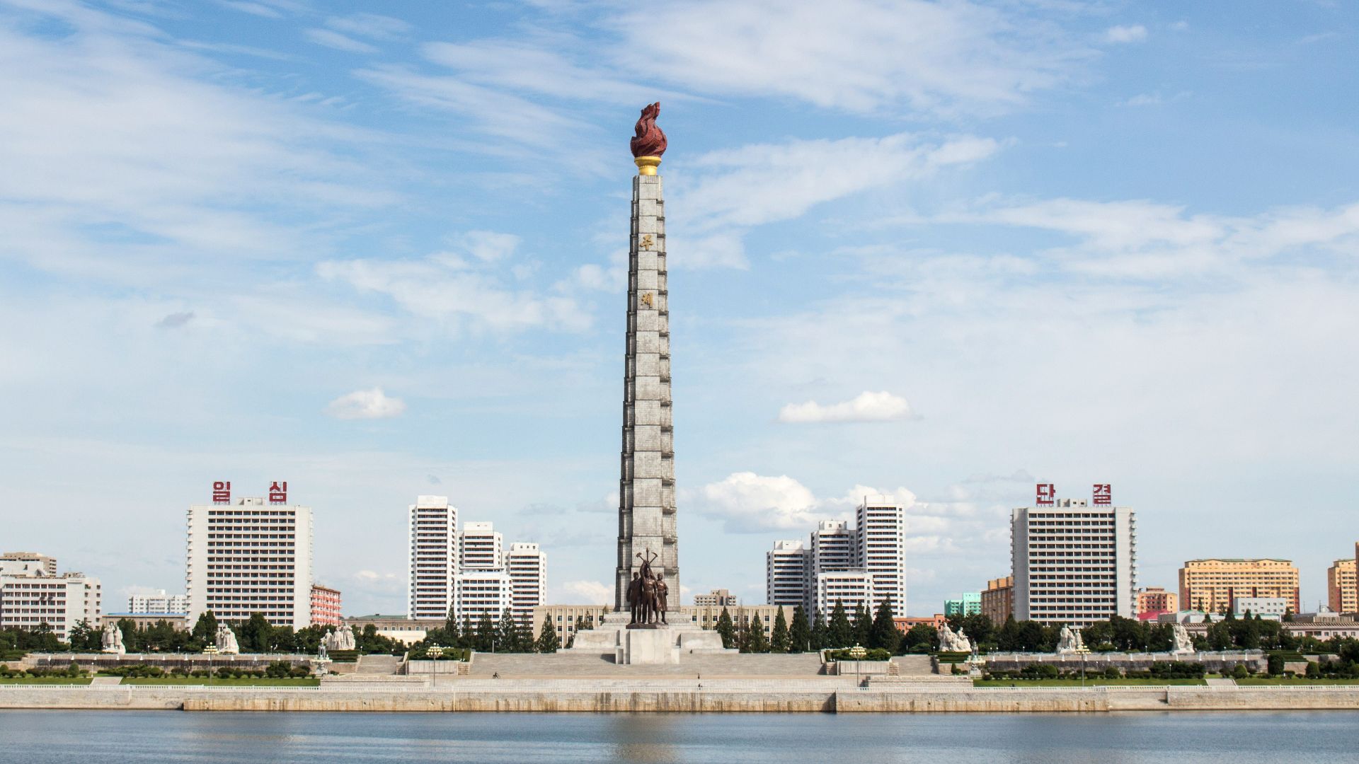 white and red tower near body of water during daytime
