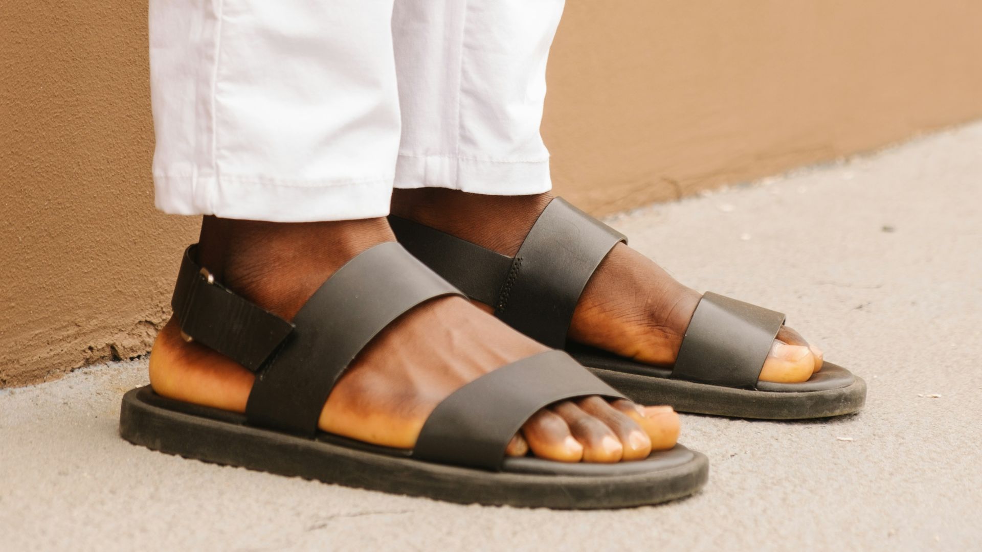 person wearing black leather sandals