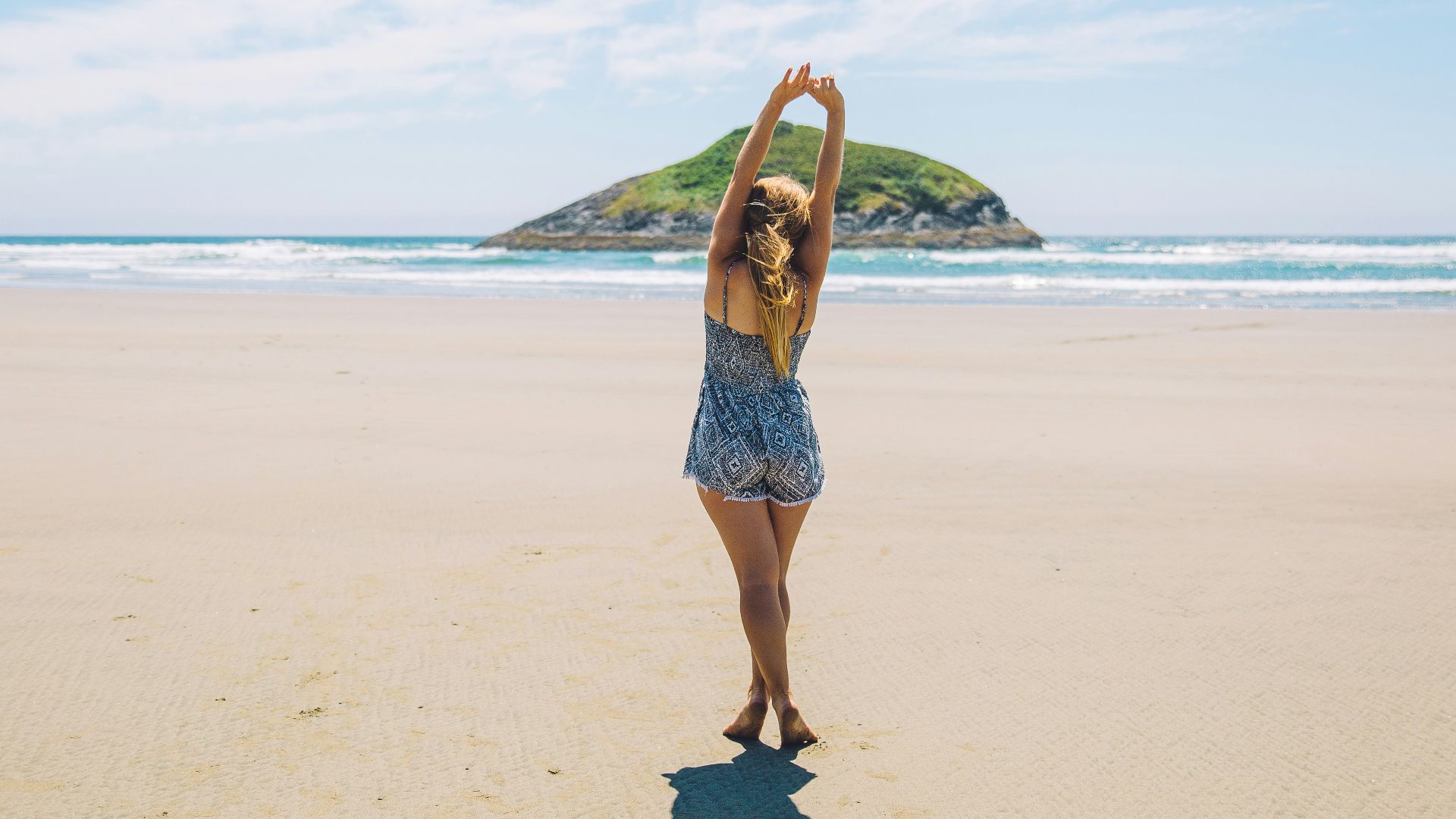 woman on seashore near island under blue sky
