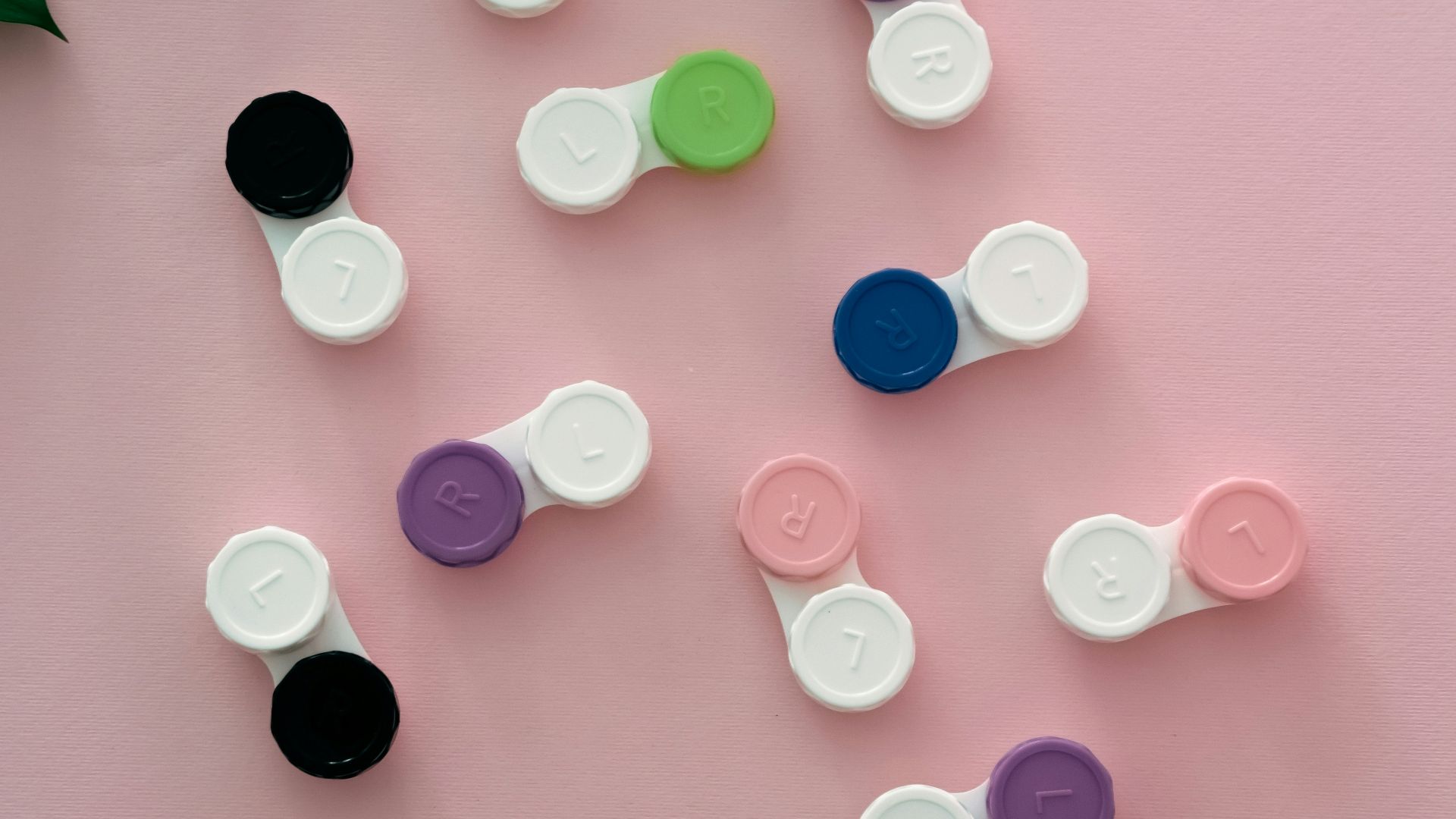 a group of different colored buttons on a pink surface