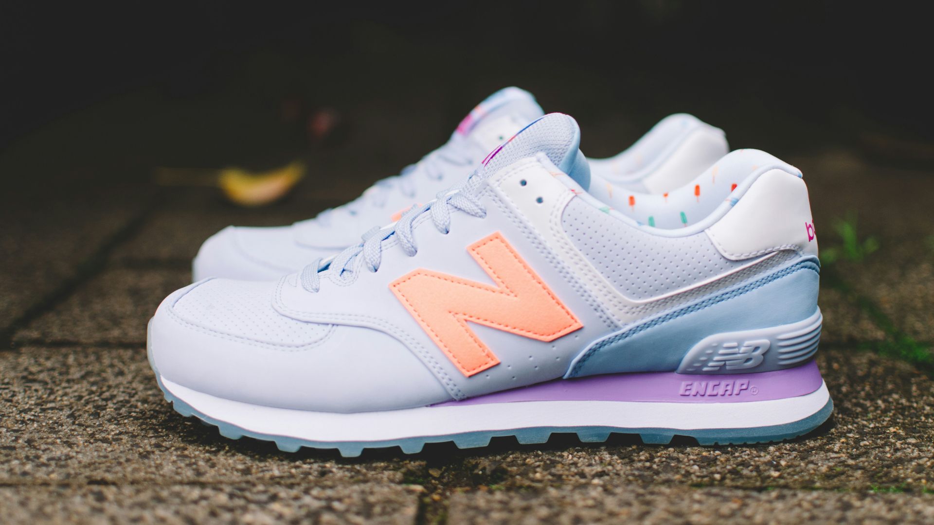 photo of gray-and-orange New Balance Encap shoes on floor