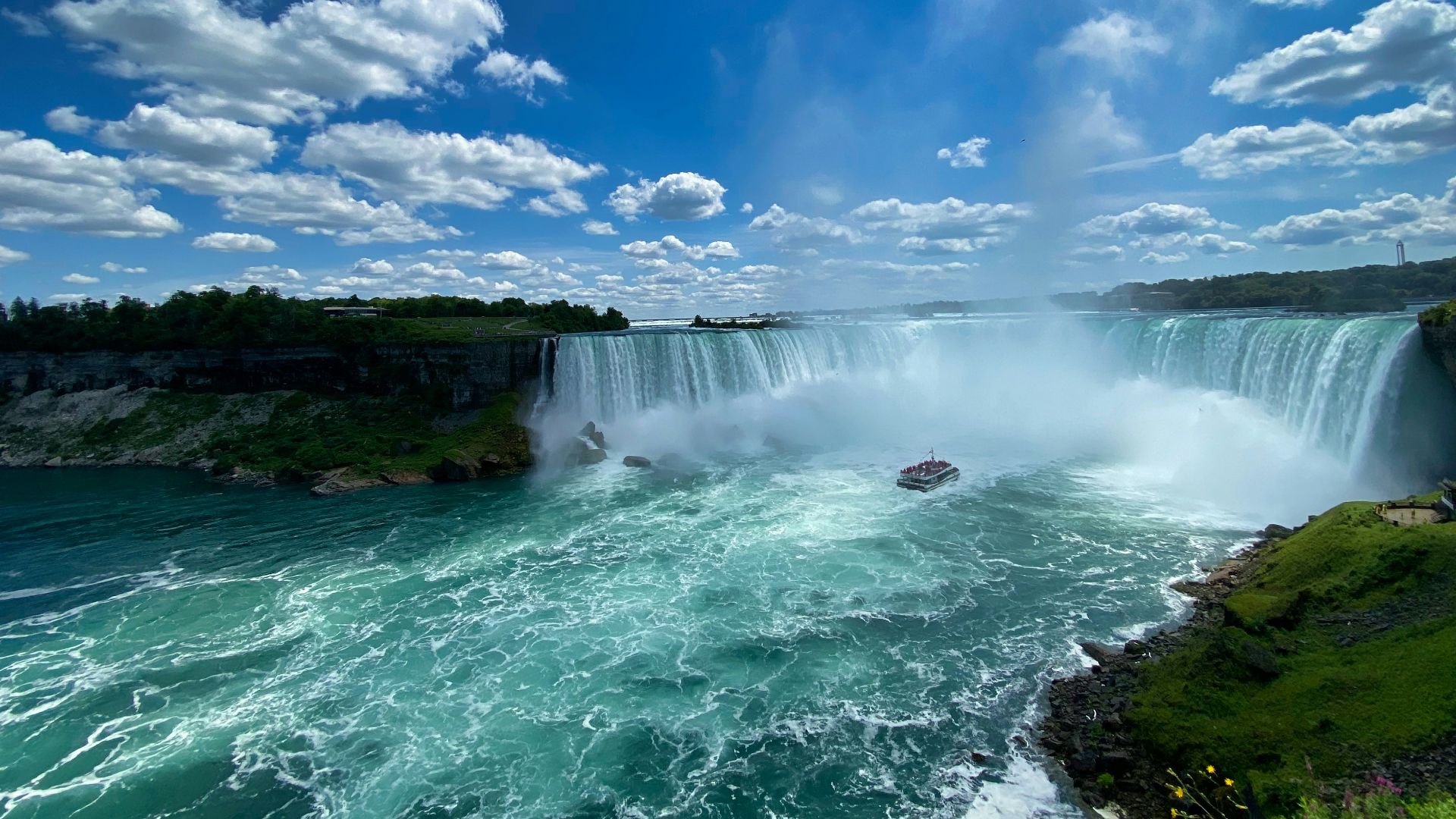 waterfalls under blue sky and white clouds during daytime