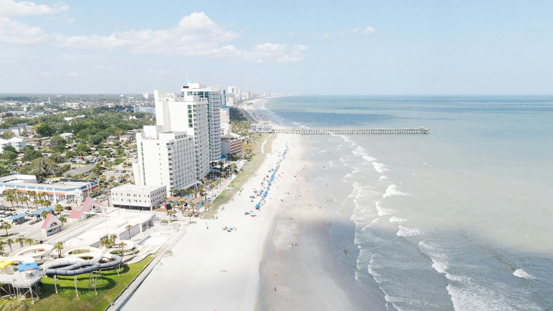 a beach with people on it and buildings by it
