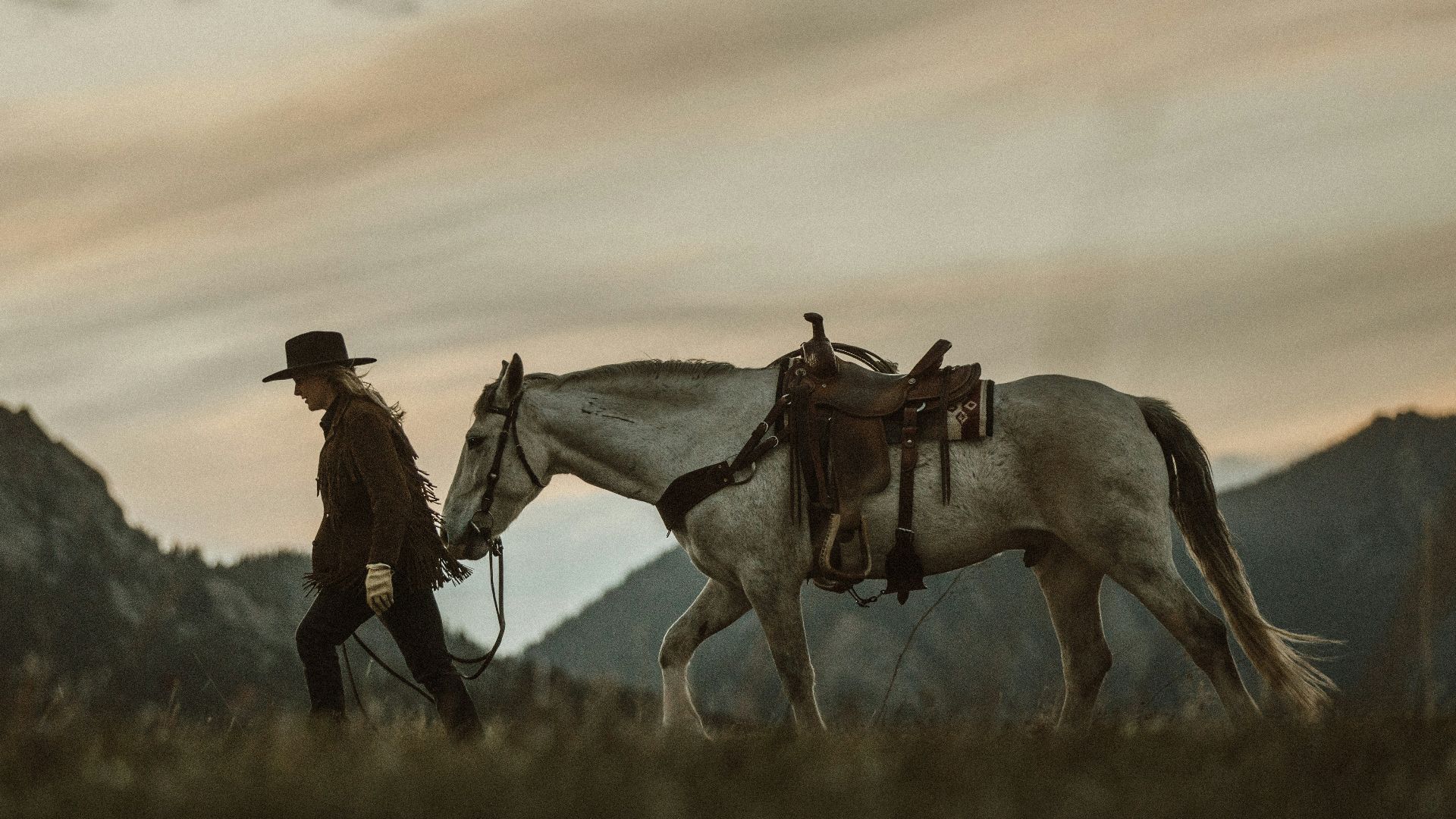 man in red jacket standing beside white horse during daytime