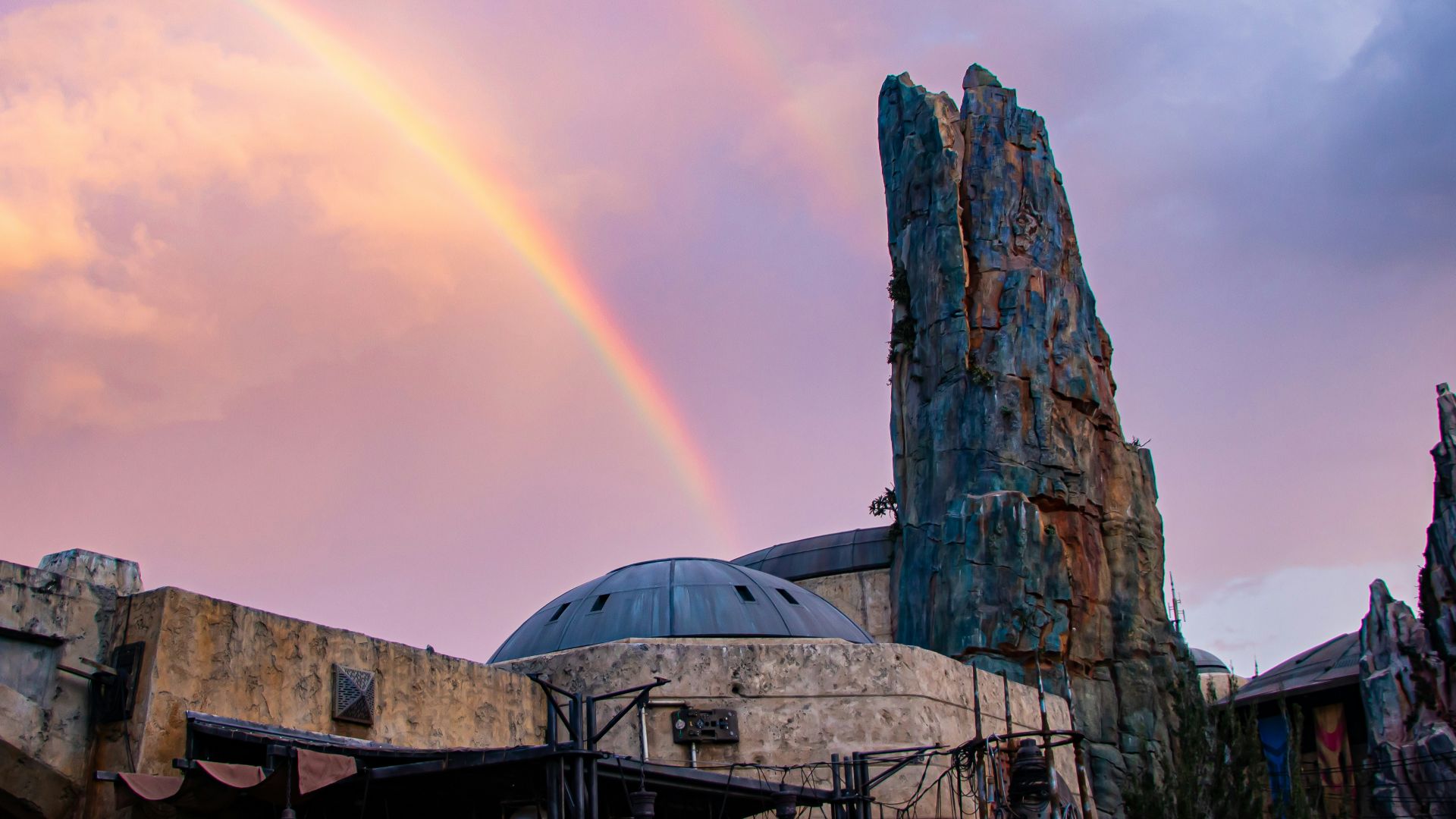 a rainbow is in the sky over a building