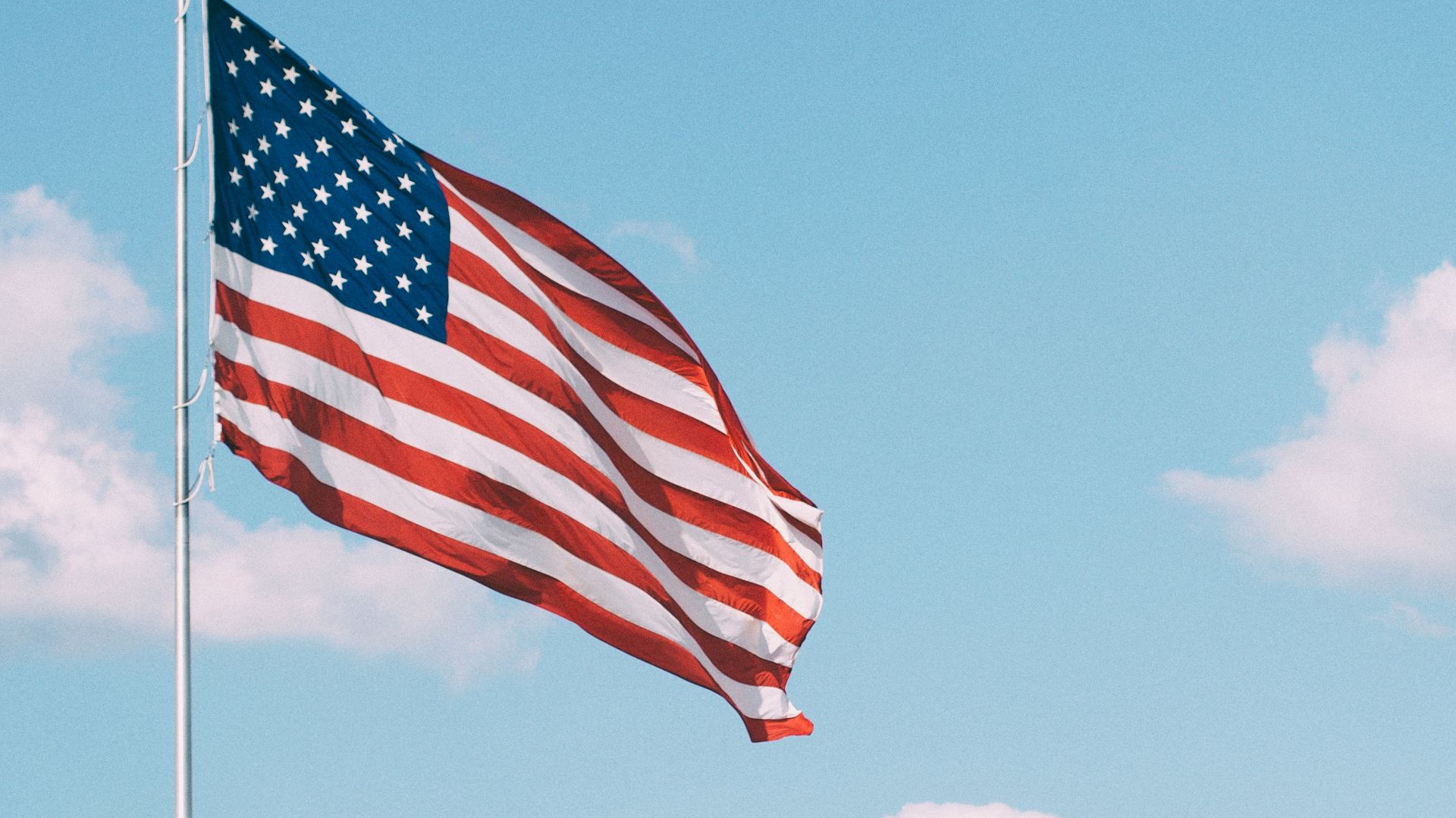 flag of U.S.A. under white clouds during daytime