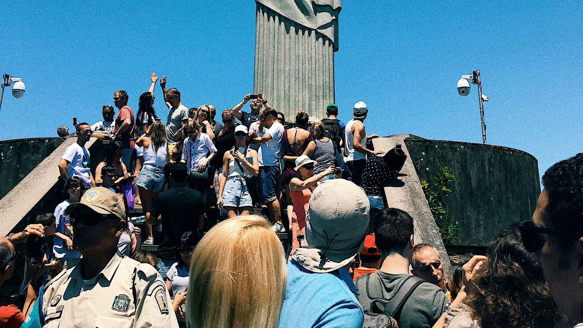 people gathering in a park with statue of liberty in the distance