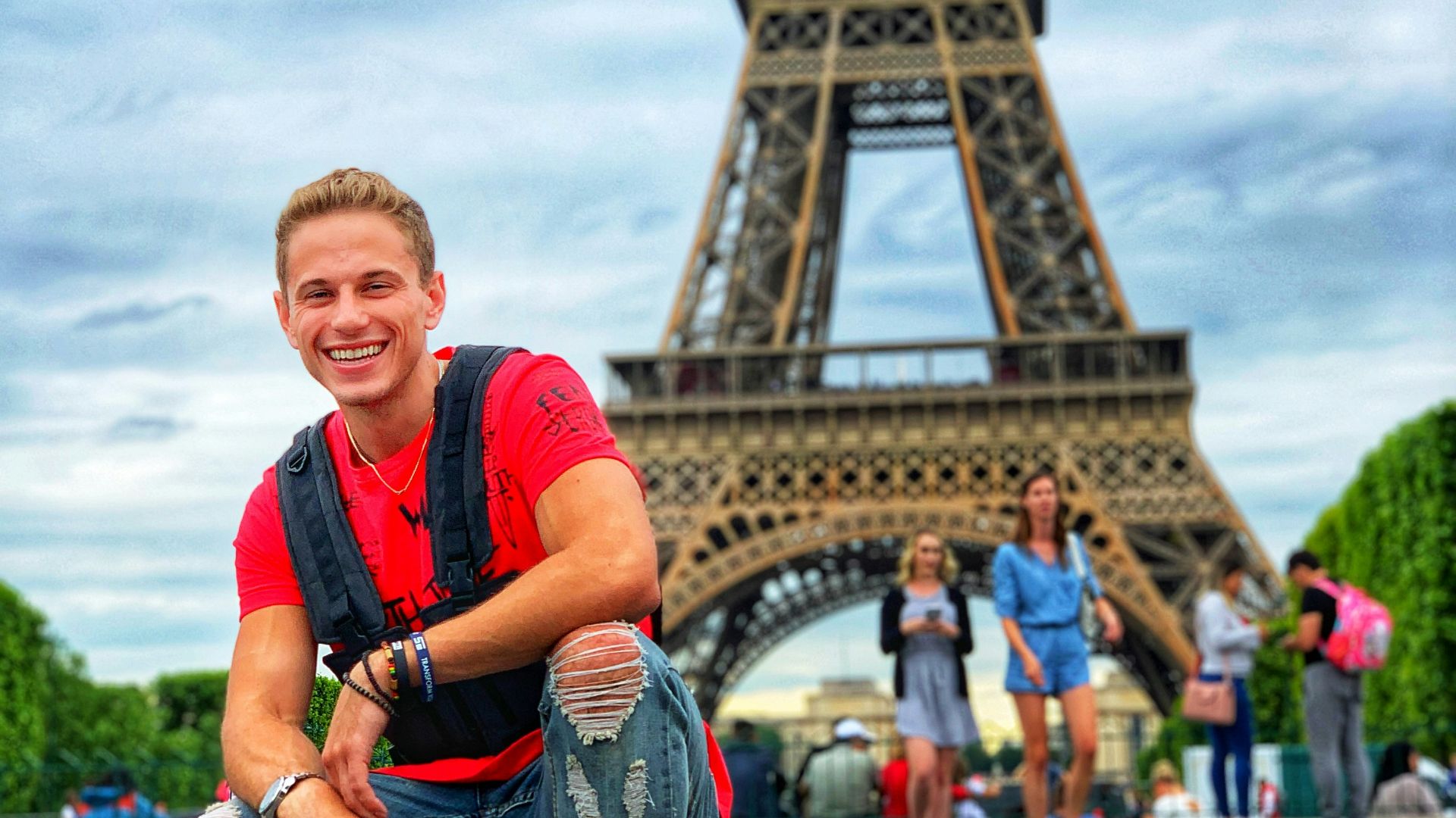 smiling man sitting by group of people near Eiffel tower