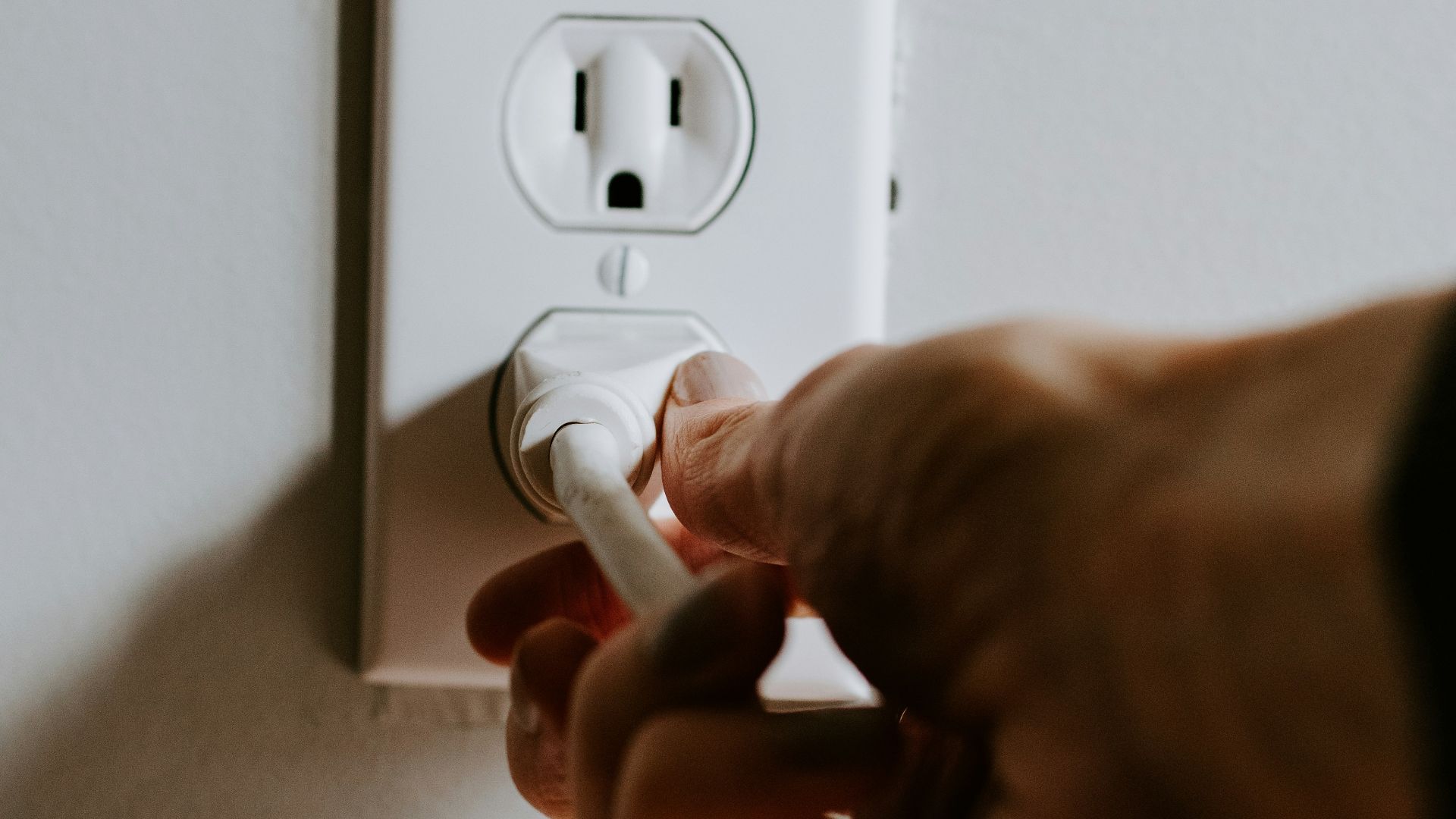 person holding white electric plug