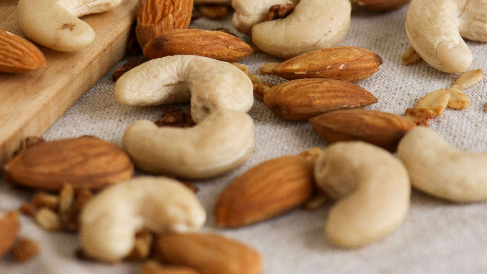 brown almond nuts on white textile