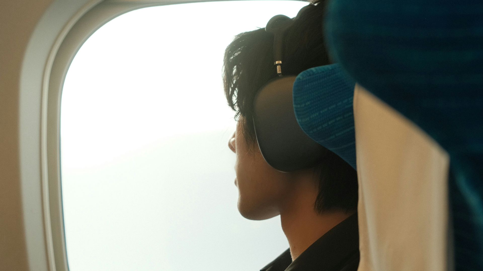 Man looks out of an airplane window.