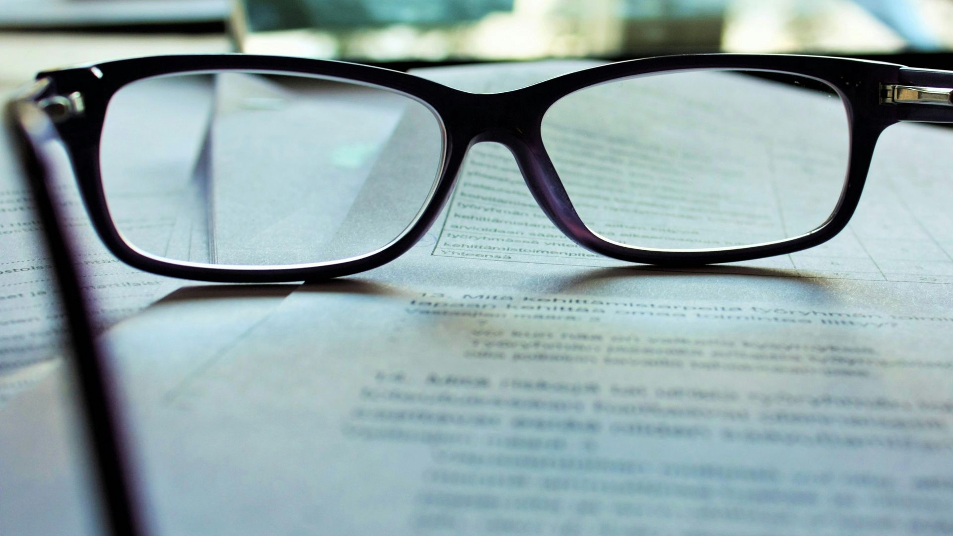 black-framed eyeglasses on white printing paper