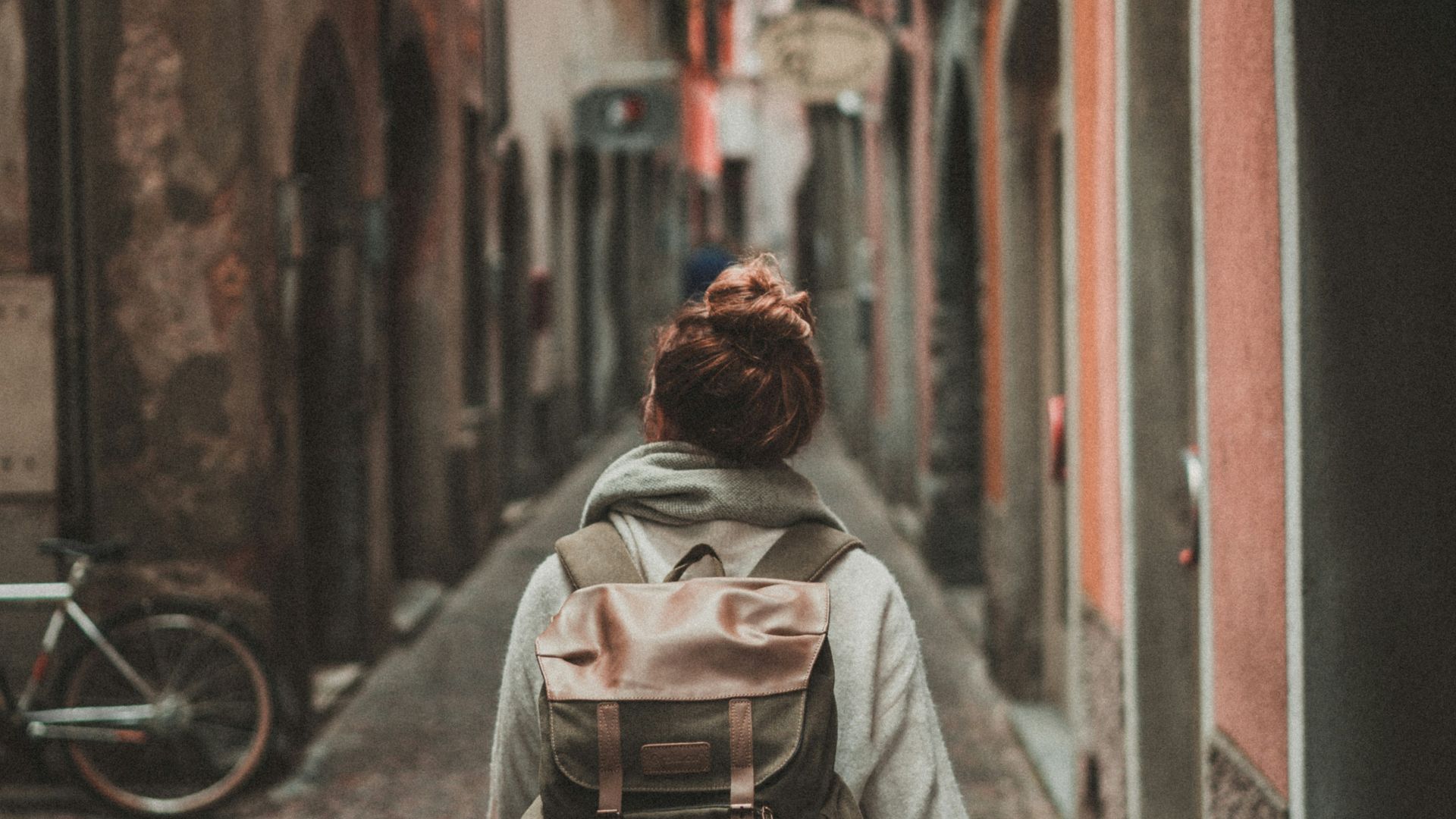 woman walking on street surrounded by buildings