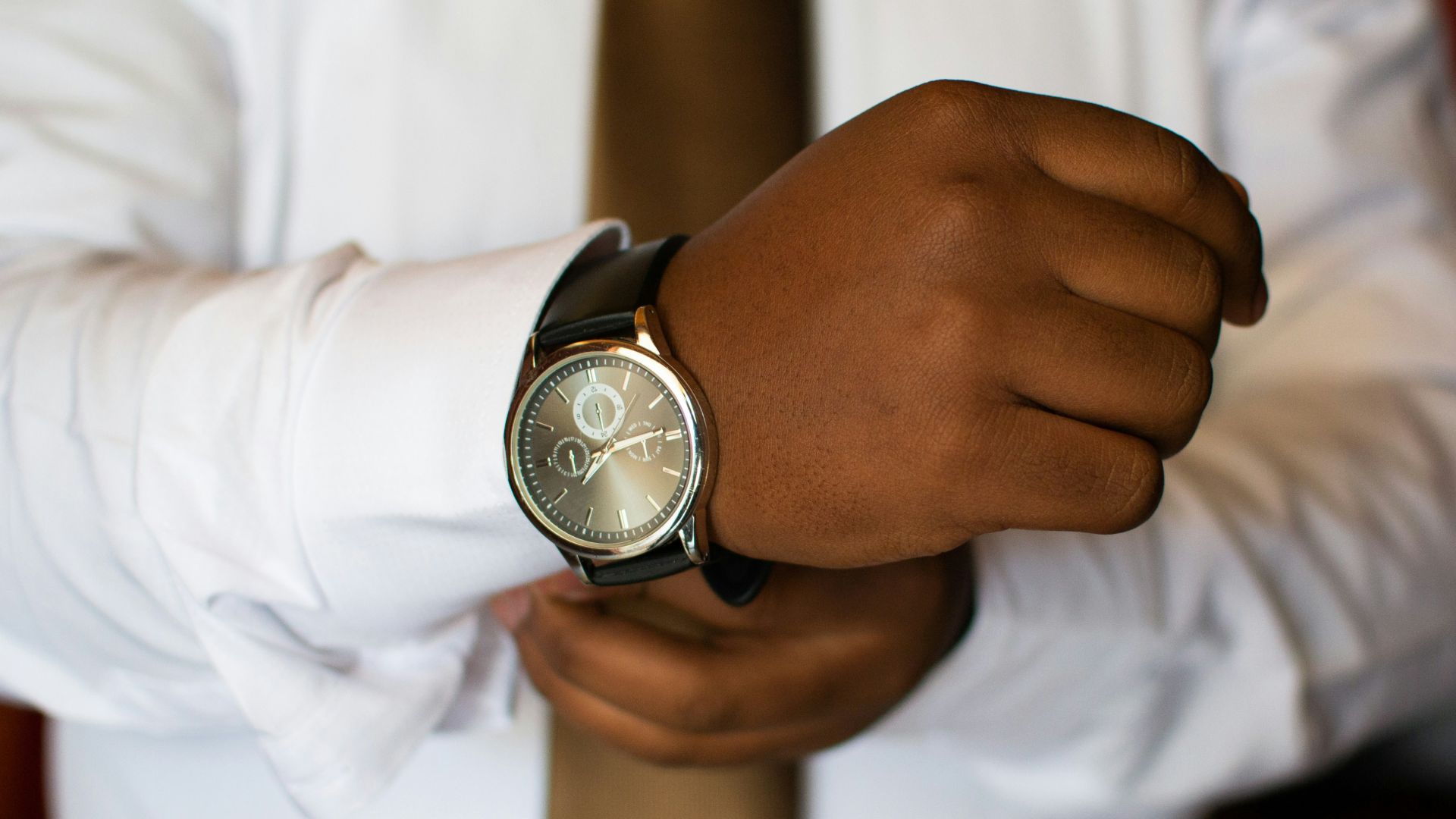 man wearing white dress shirt and black watch