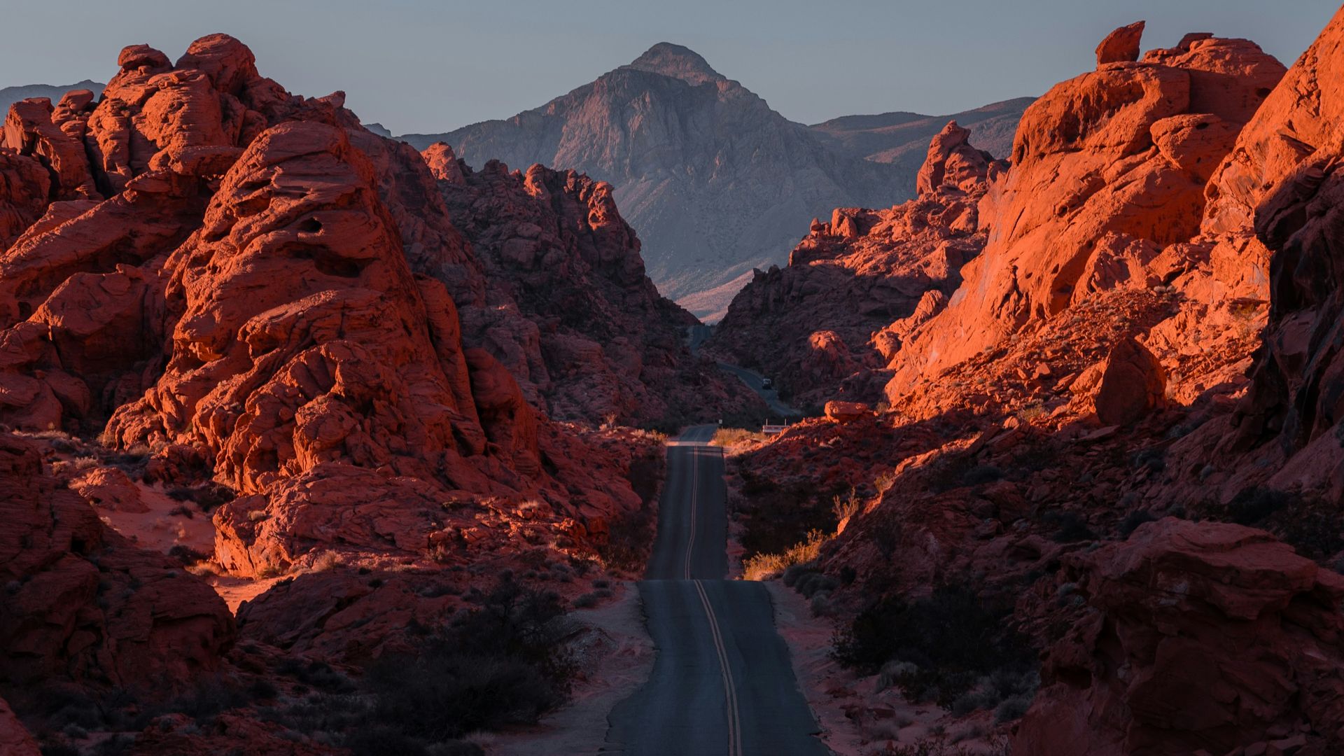 a road in the middle of a desert with mountains in the background