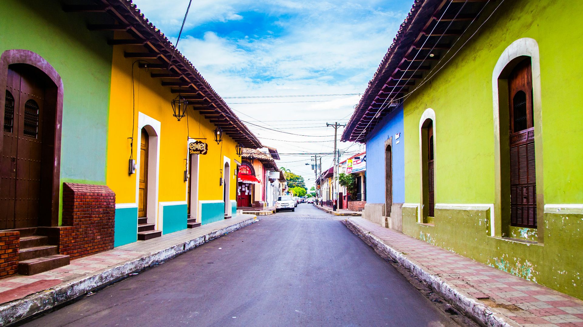 pathway of houses under blue clouds during daytime