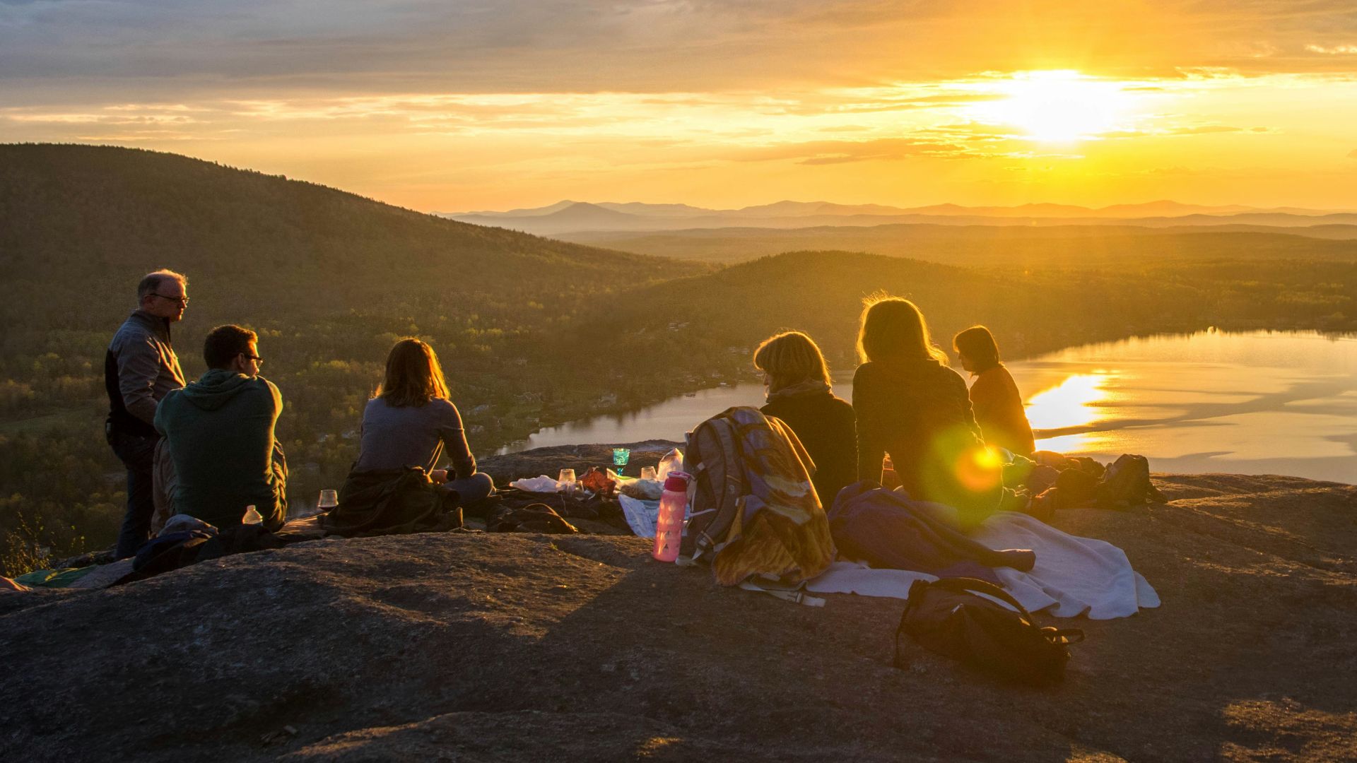 group of people sirring under sunset