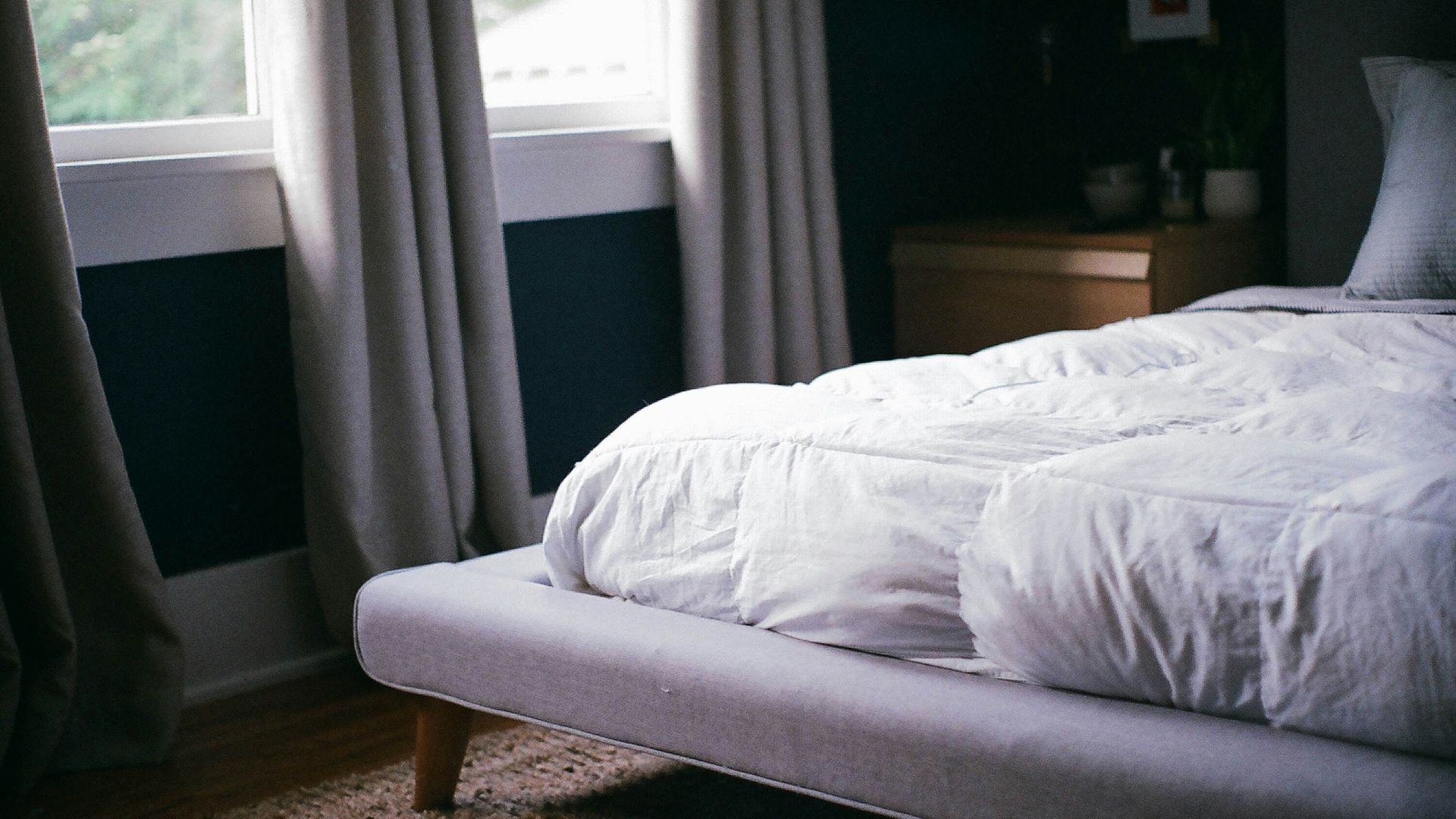 white bed by the window during daytime