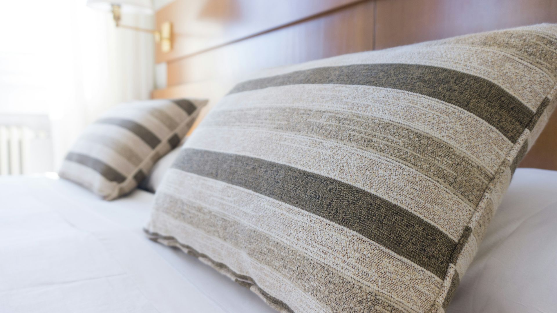 gray and black throw pillow on bed