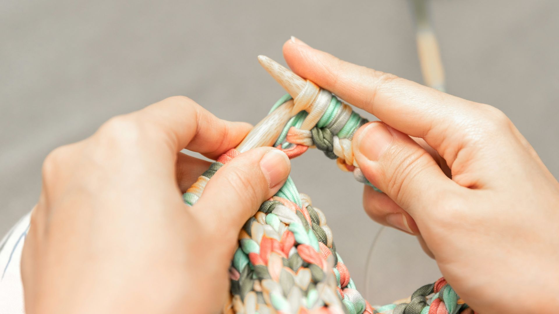 a woman is knitting a piece of fabric