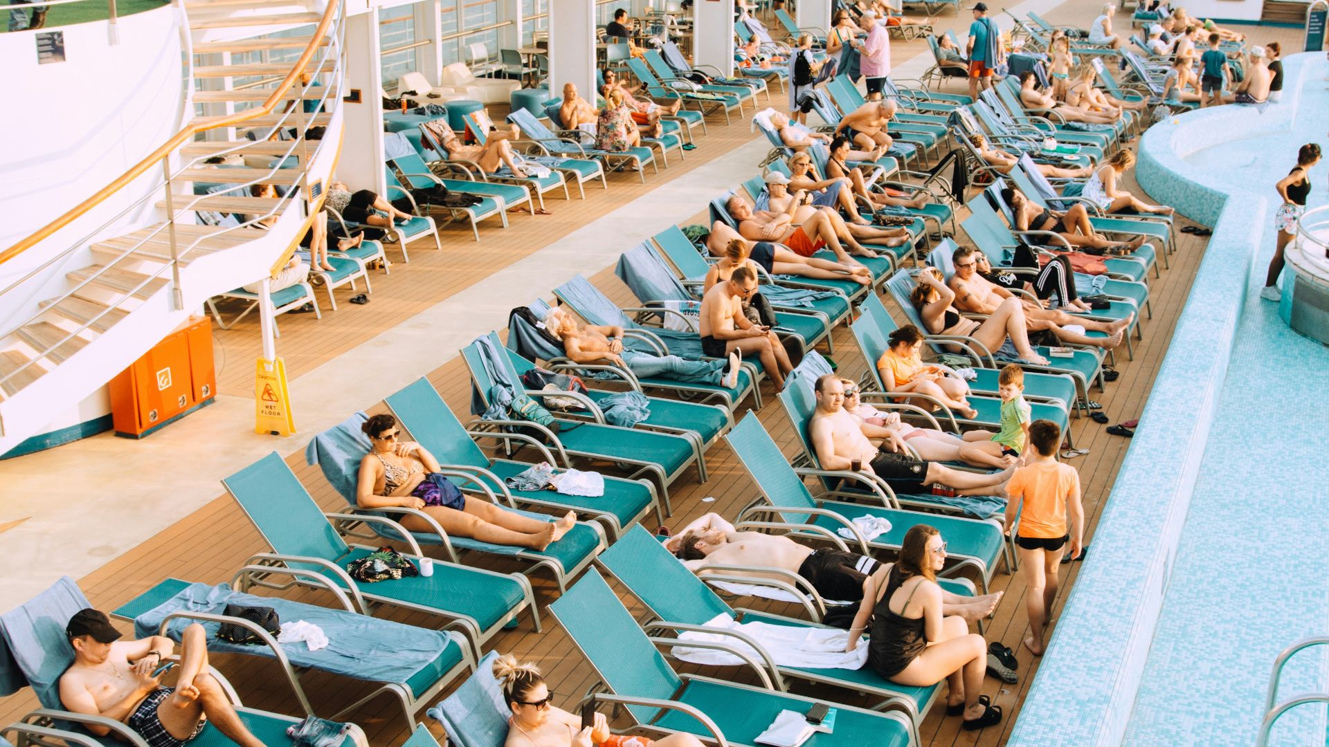 people lying on blue and white lounge chairs