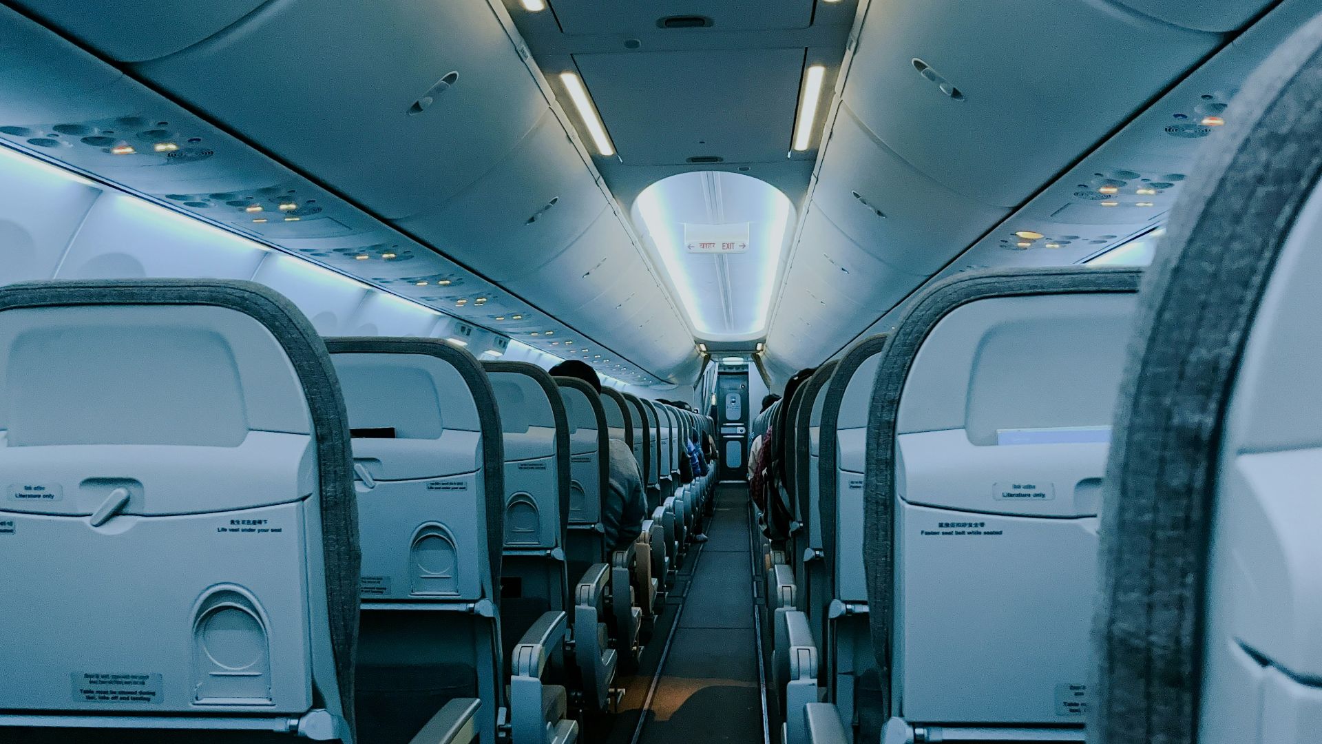 The inside of an airplane with rows of empty seats