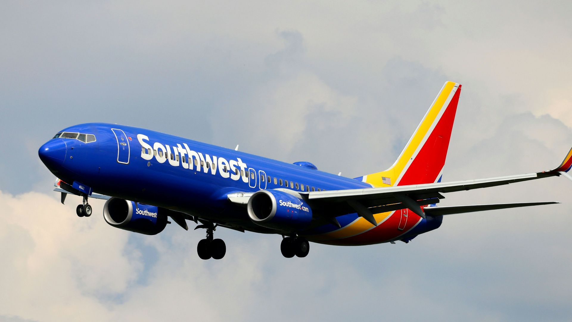 a blue and white airplane flying in the sky