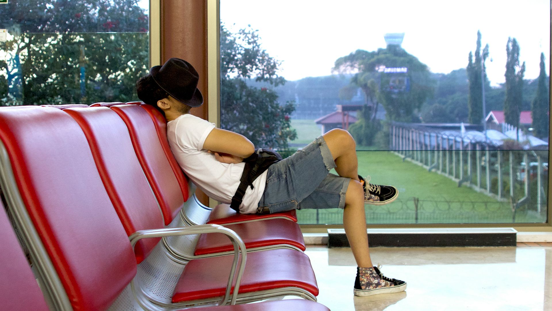 unknown person sitting on red gang chair indoors