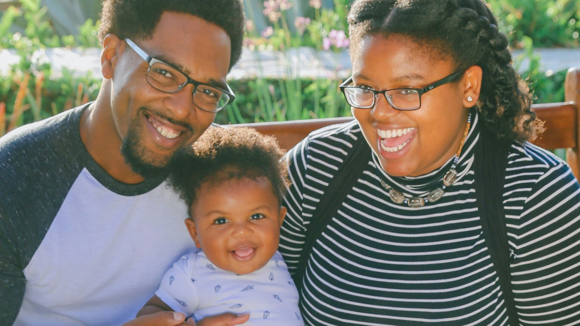 woman in black and white striped shirt carrying baby in blue onesie