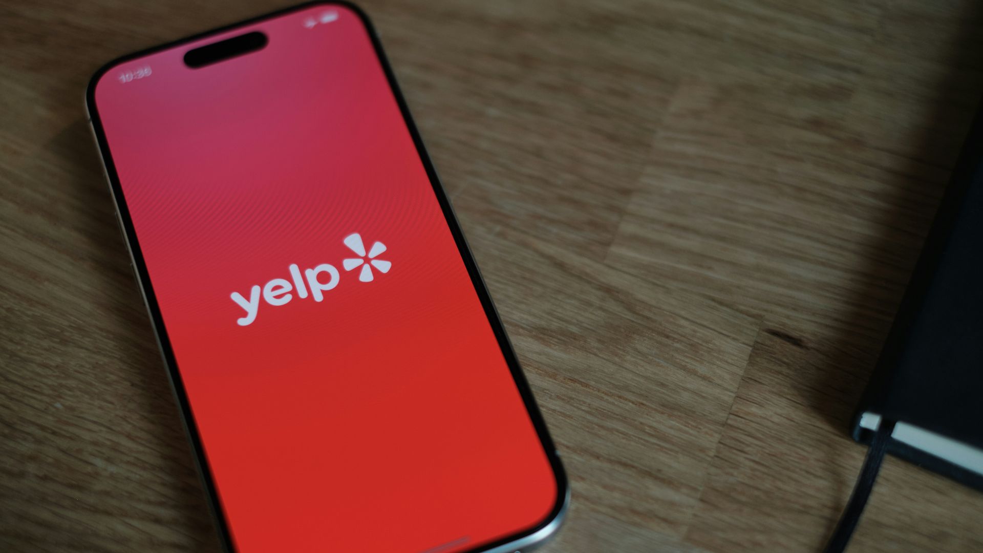 A cell phone sitting on top of a wooden table