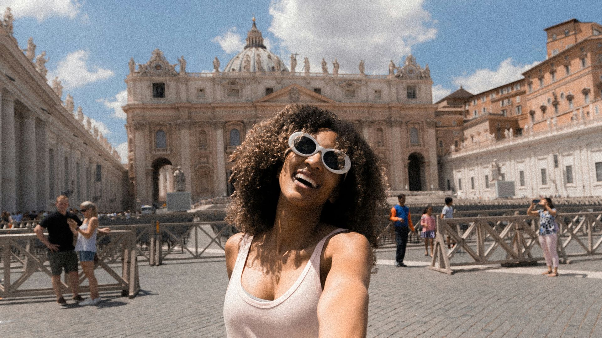 woman holding person's hand near buildings under white and blue cloudy sky